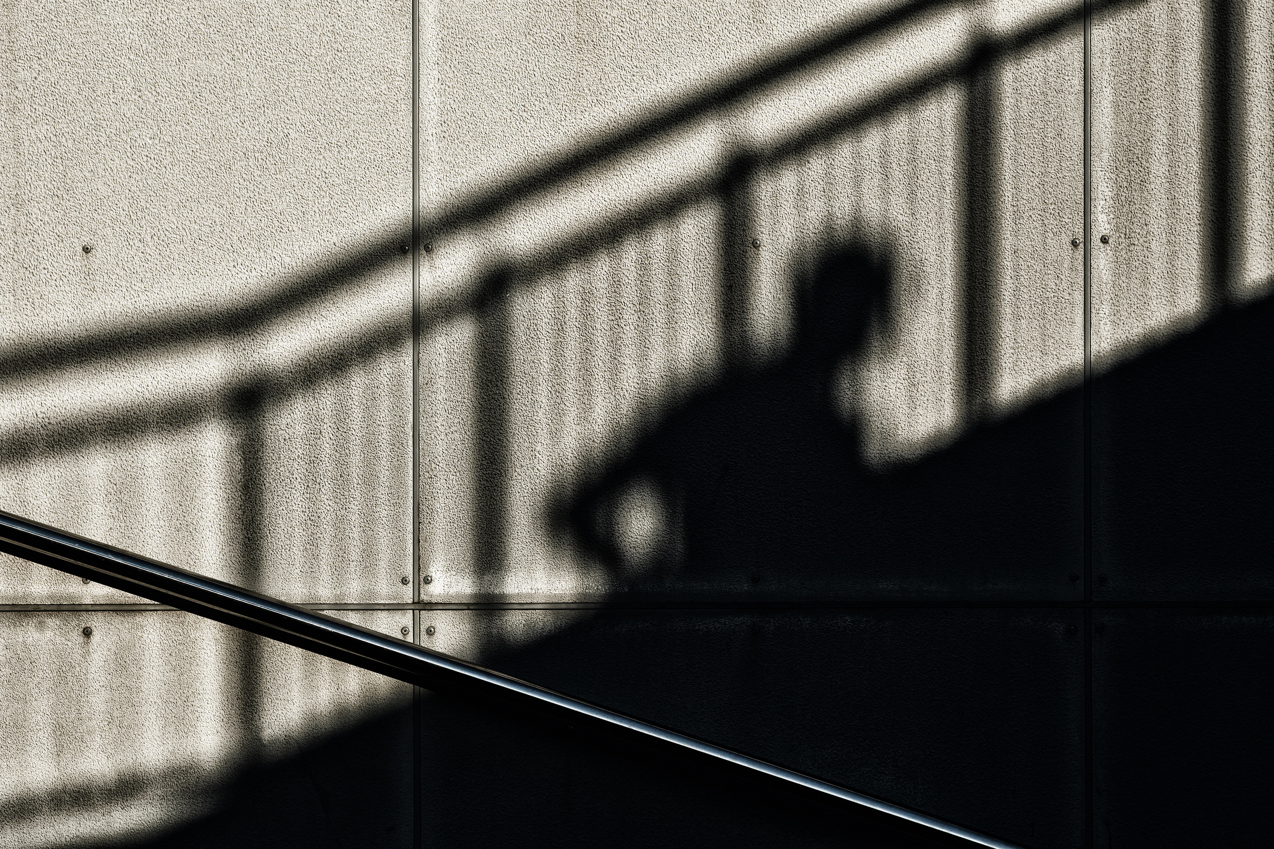 Ограждение, тень ограждения и мужчины за утренней пробежкой, Новороссийск