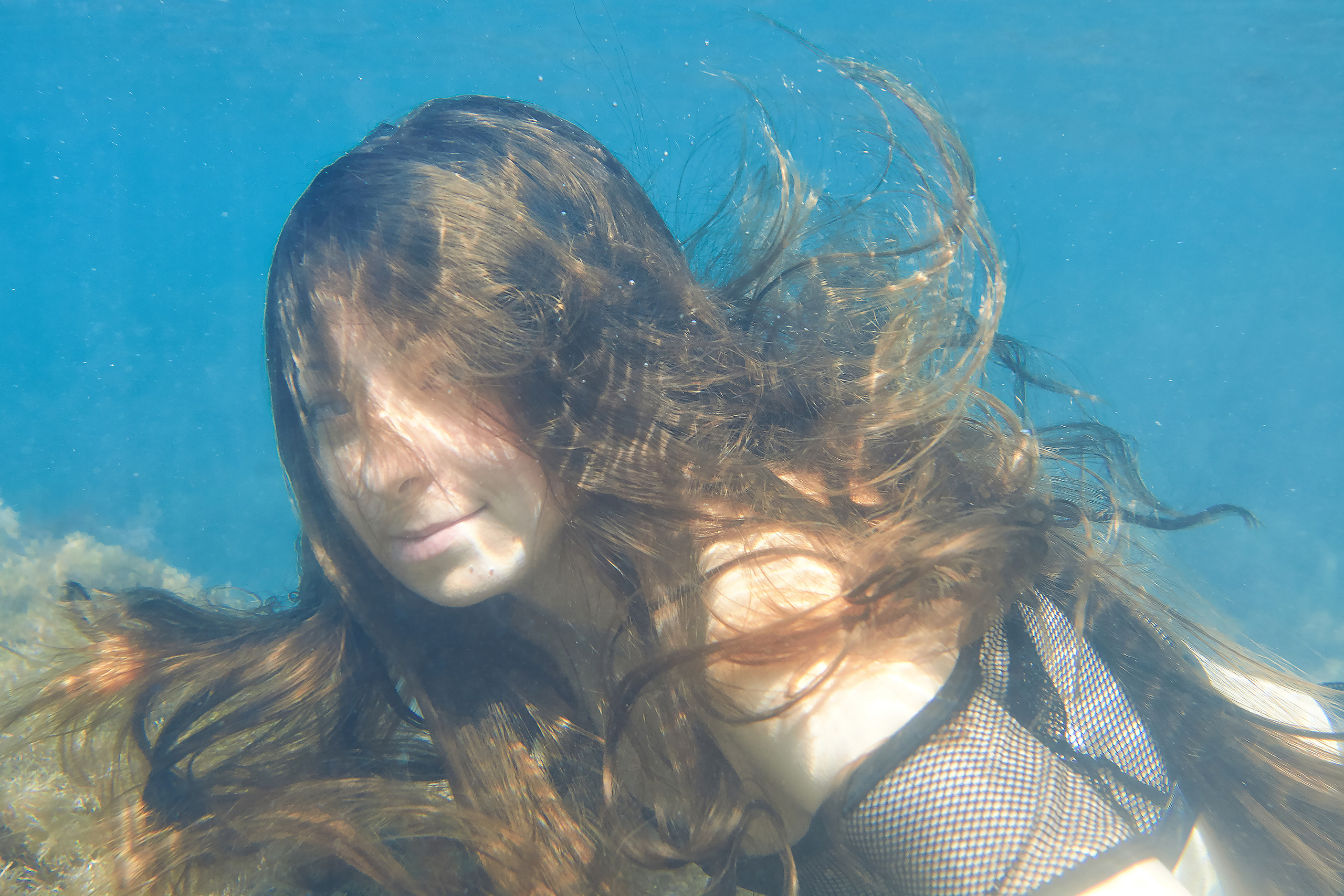 Девушка под водой с волосами на лице