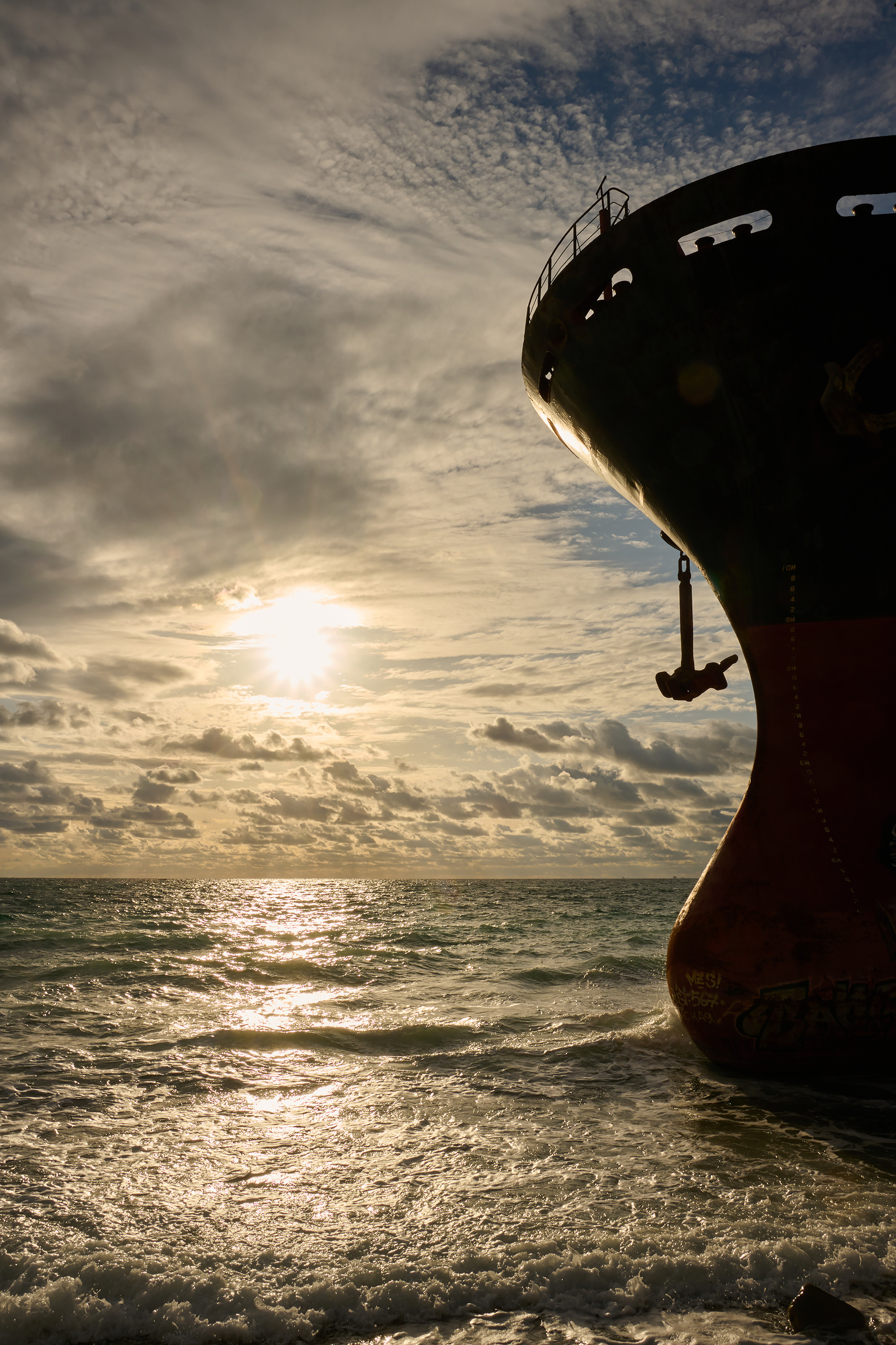 Силуэт судна на мели на фоне заката