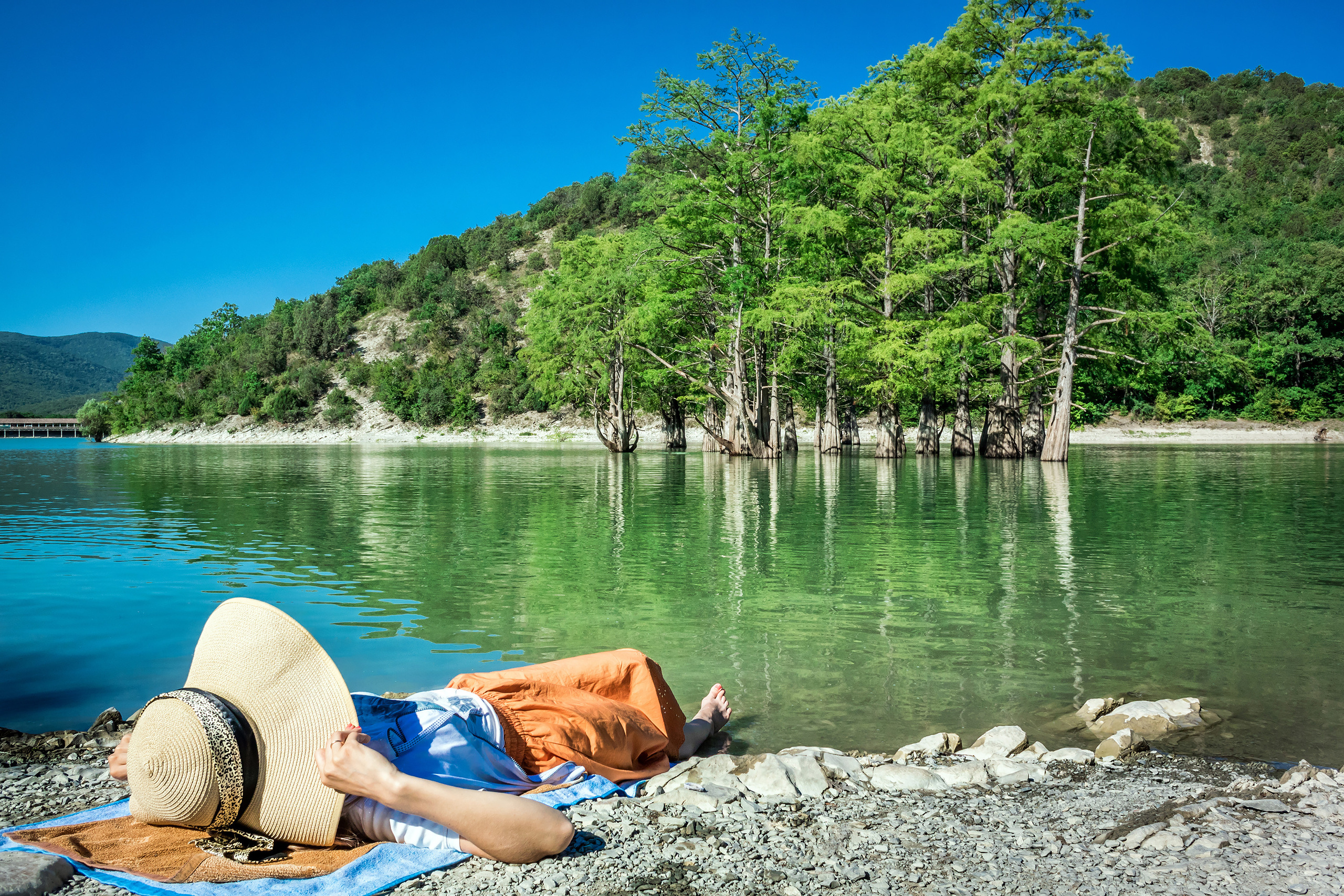 Девушка отдыхает, лежит на берегу озера, Анапа, Сукко, кипарисы