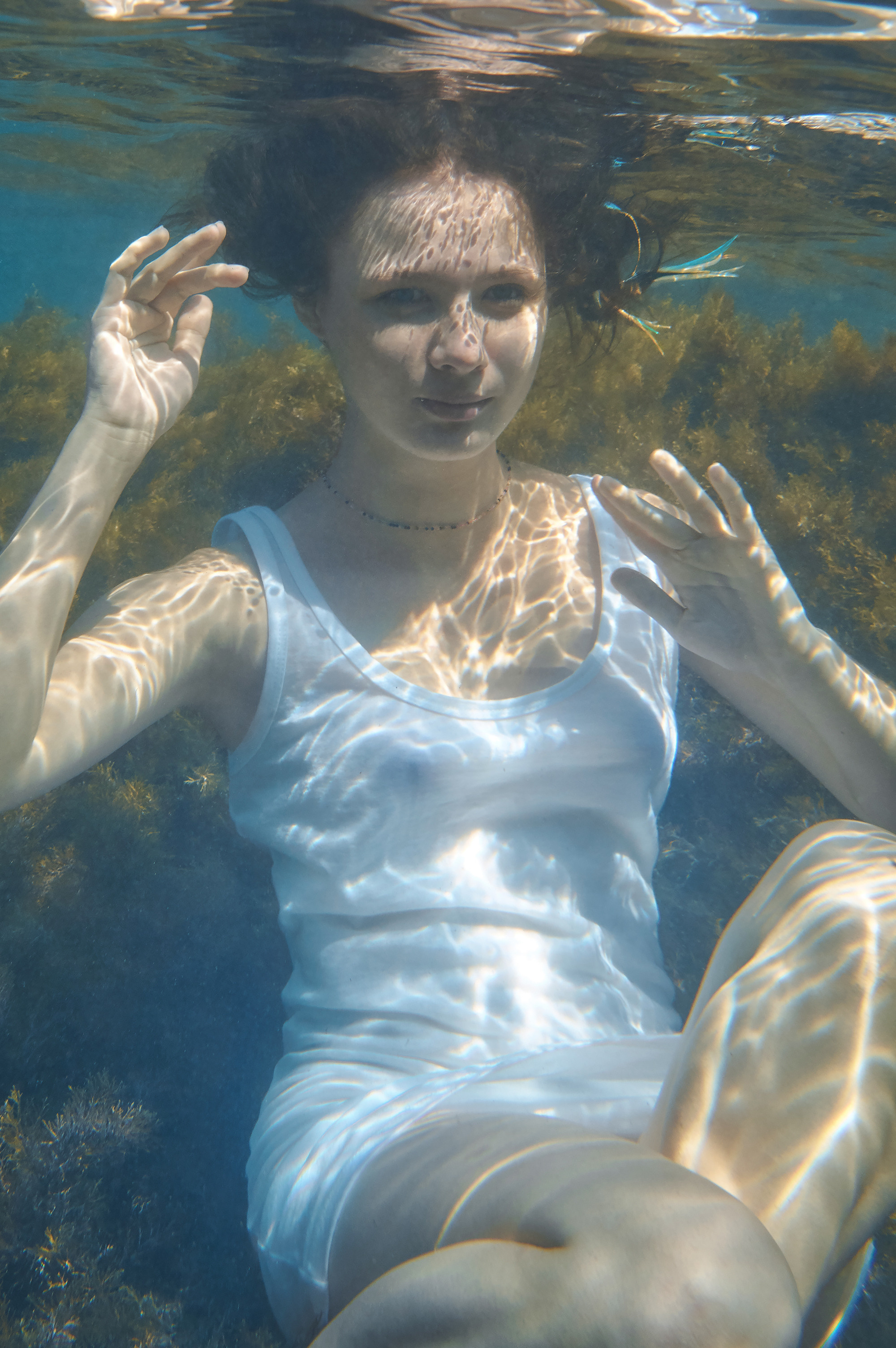 Девушка в белой майке под водой