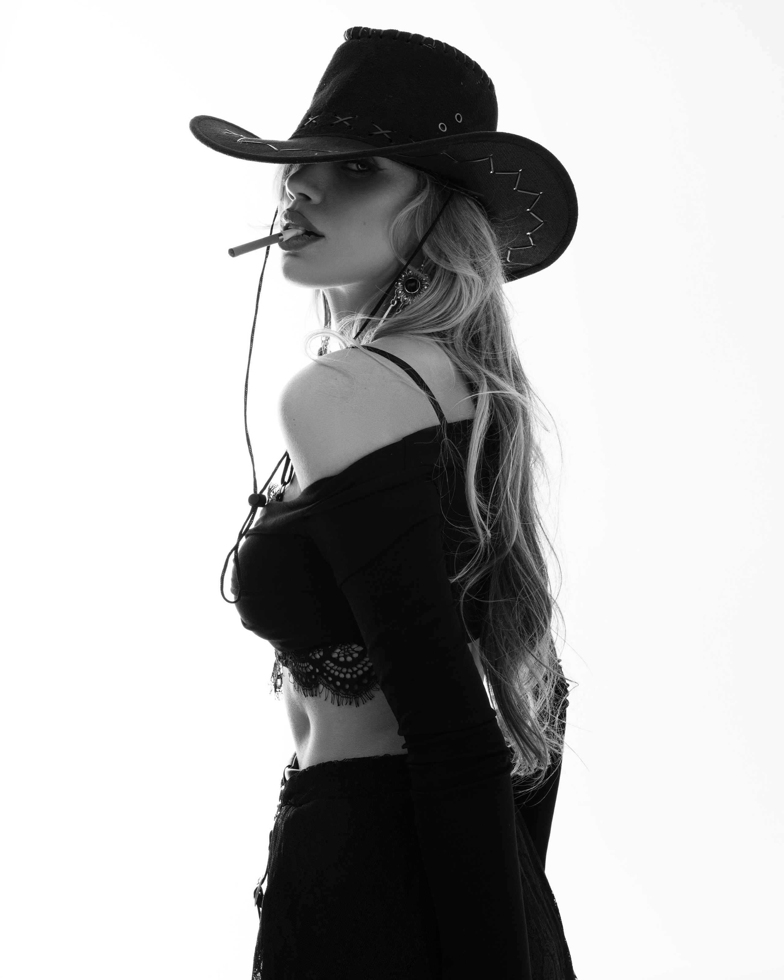 Фотосессия в ковбойском стиле, чёрно белая фотография, девушка с открытыми плечами в ковбойской шляпе 