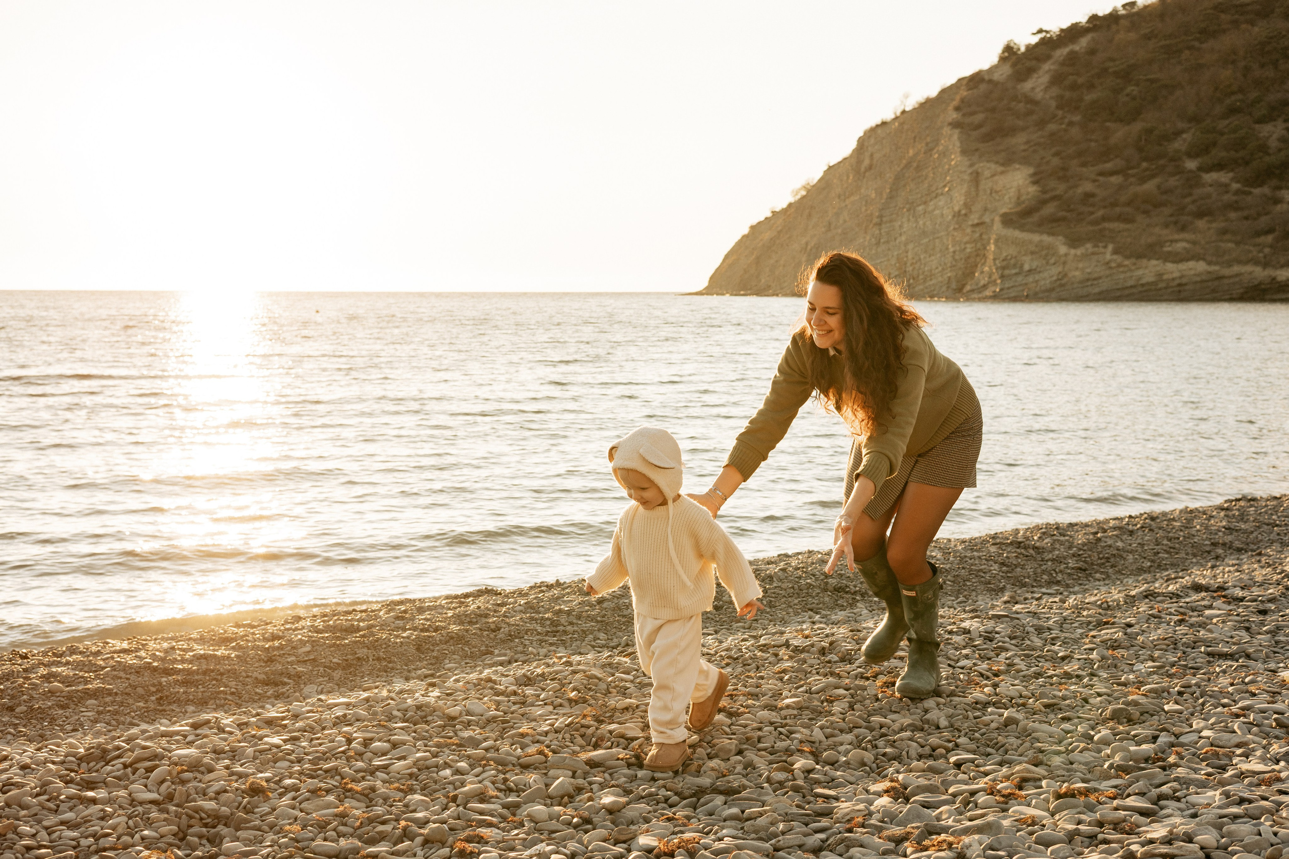 Дети весело бегут по песку на фоне виноградных холмов Абрау-Дюрсо