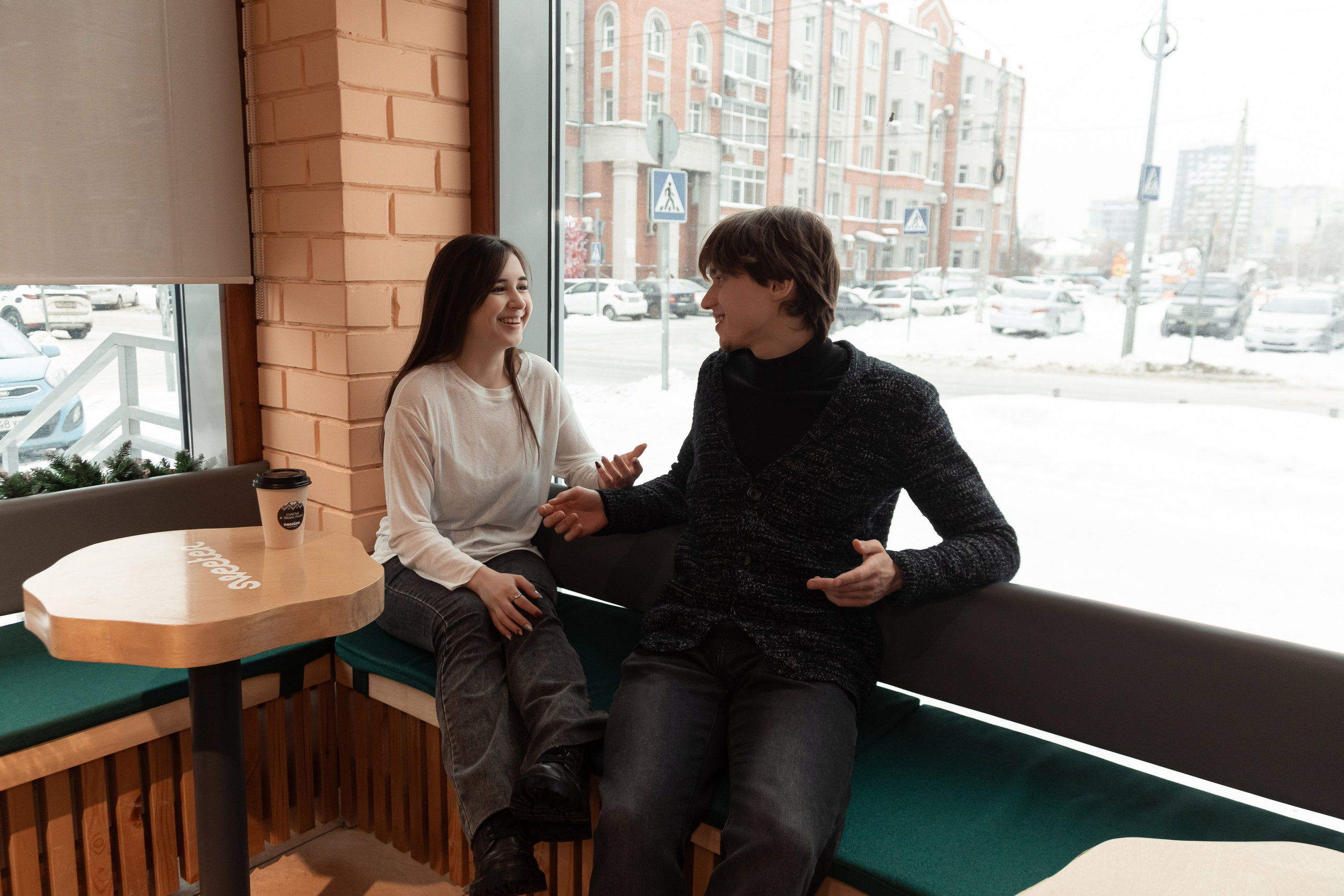 Para obshchayetsya v kafe, zimniy vid iz okna, romanticheskaya vstrecha, foto pary (Пара общается в кафе, зимний вид из окна, романтическая встреча, фото пары)