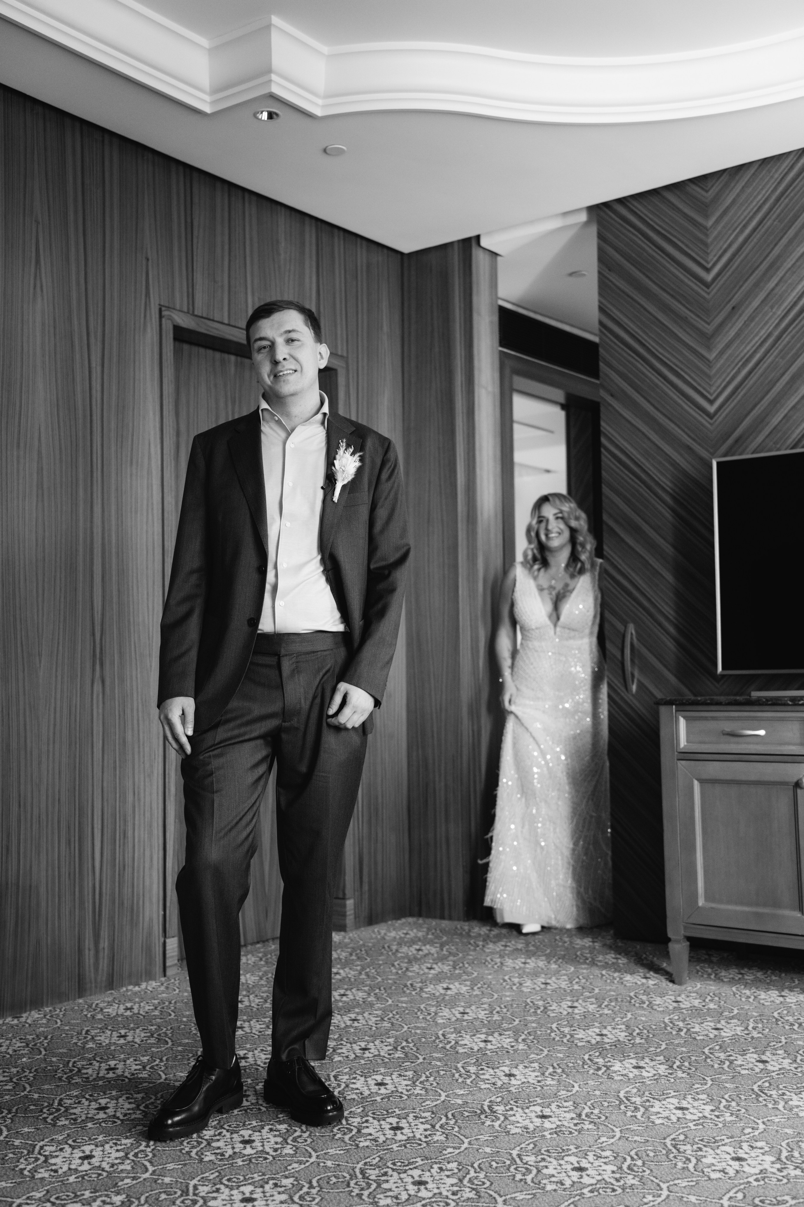 Невеста и жених видят друг друга впервые в свадебный день — эмоциональный момент, запечатленный фотографом.