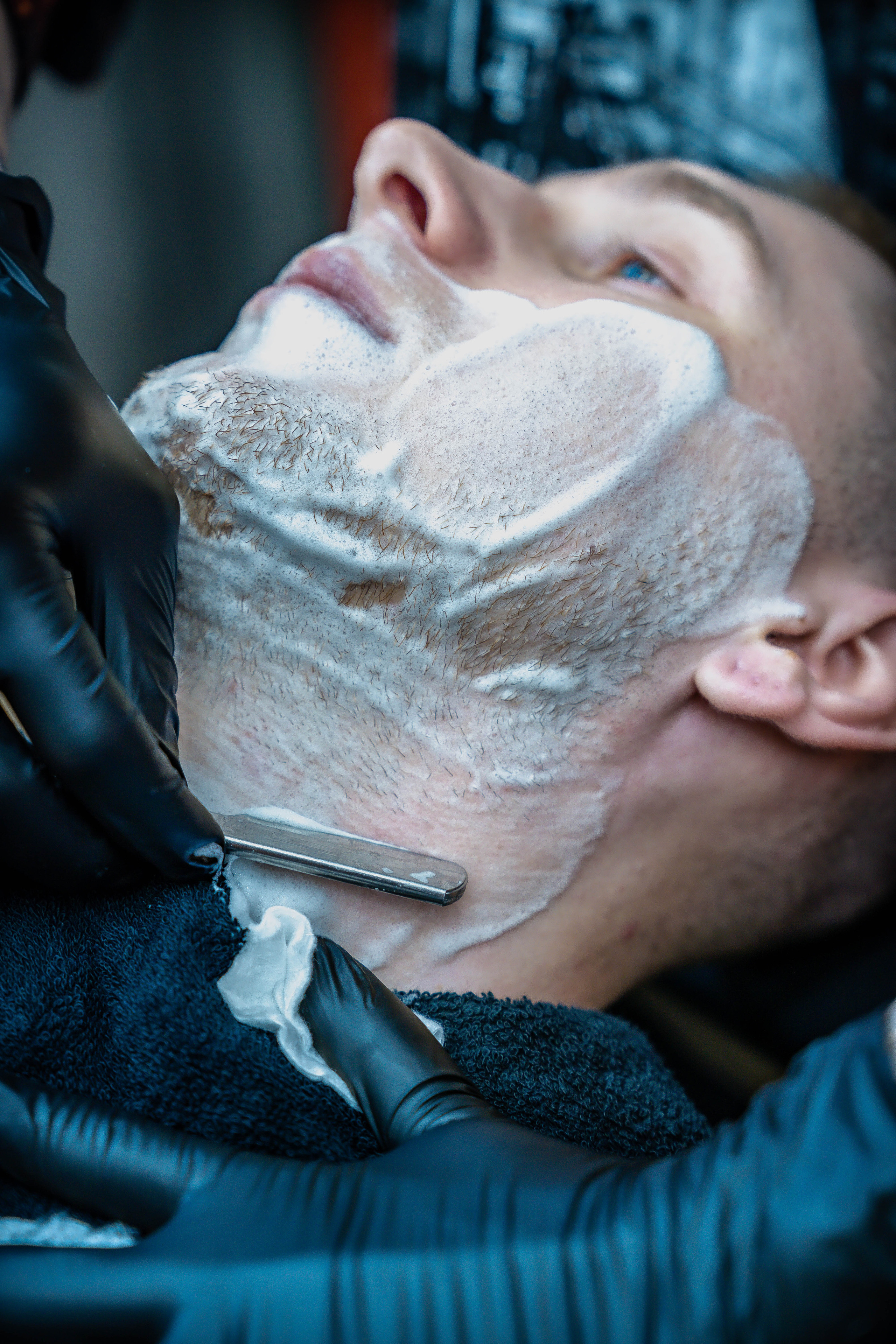 барбер бреет клиента опасной бритвой