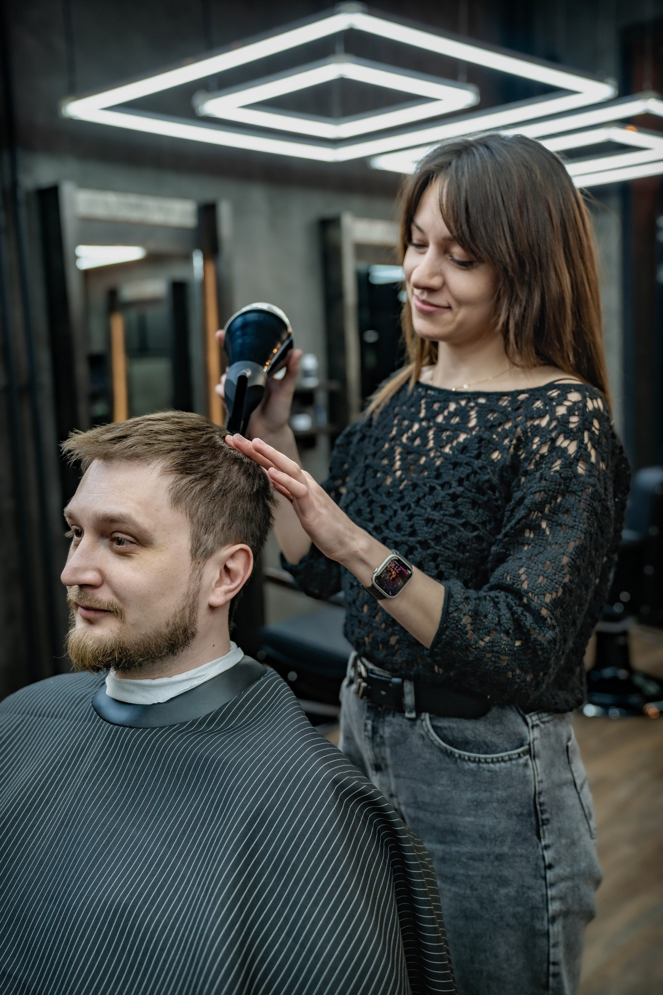 девушка барбер сушка волос феном