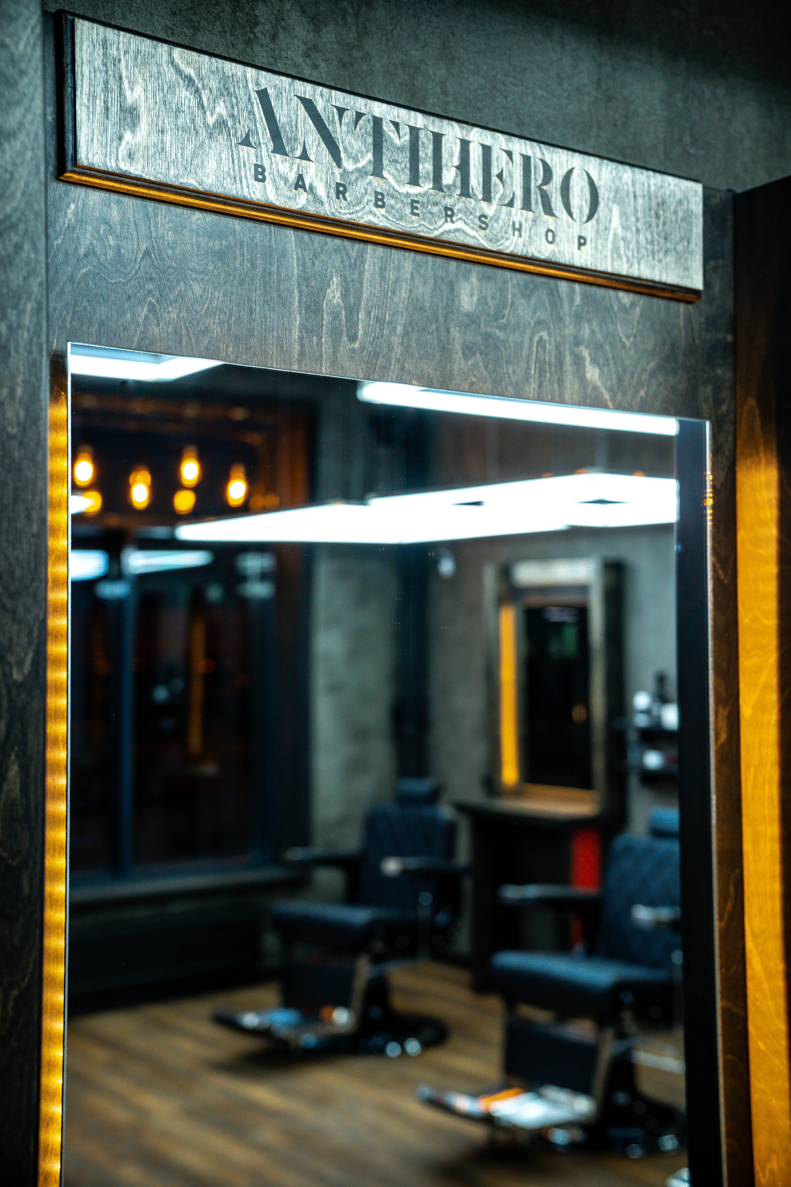 Зеркало в барбершопе и надпись Antihero