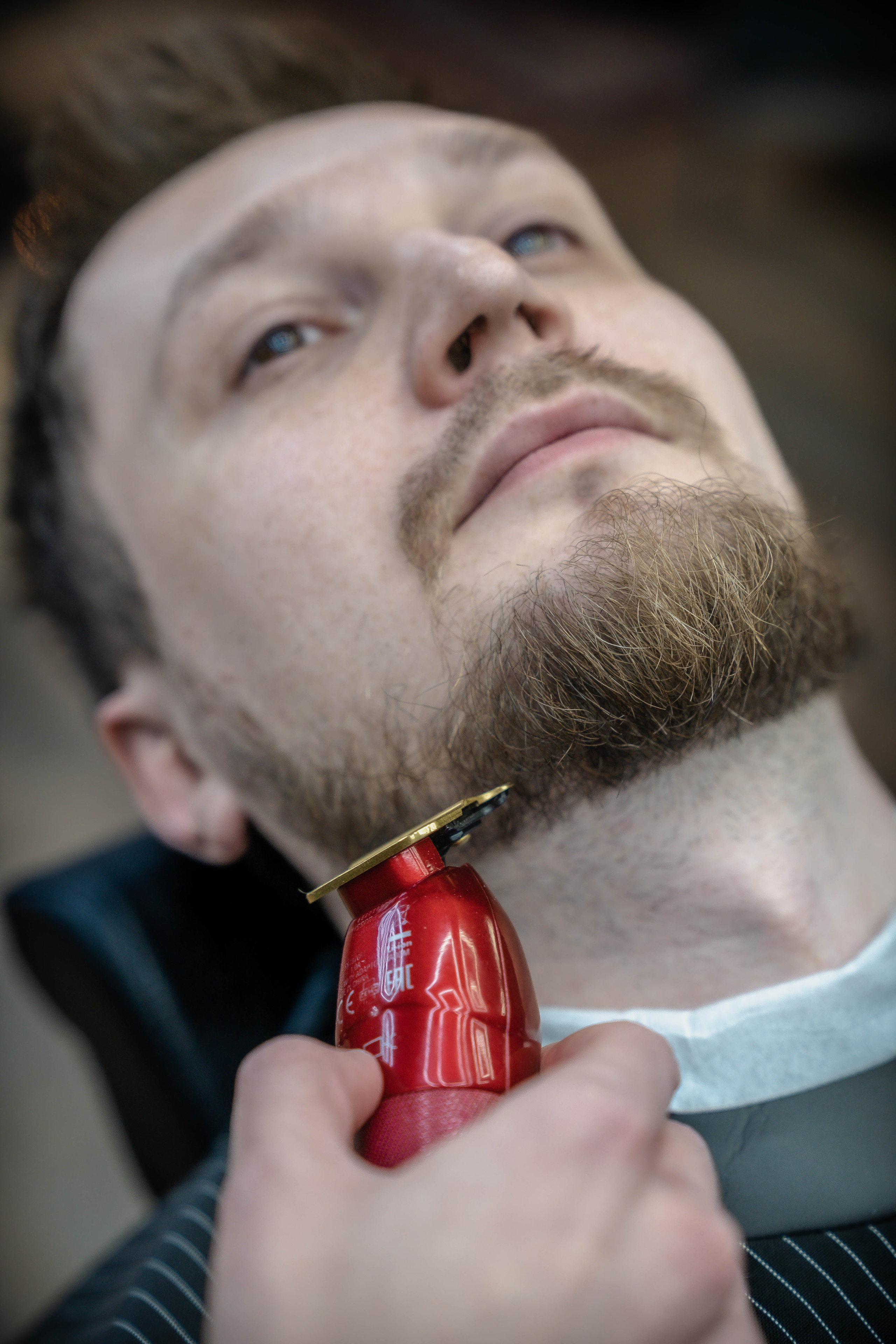 барбер в руке красная машинка для бороды