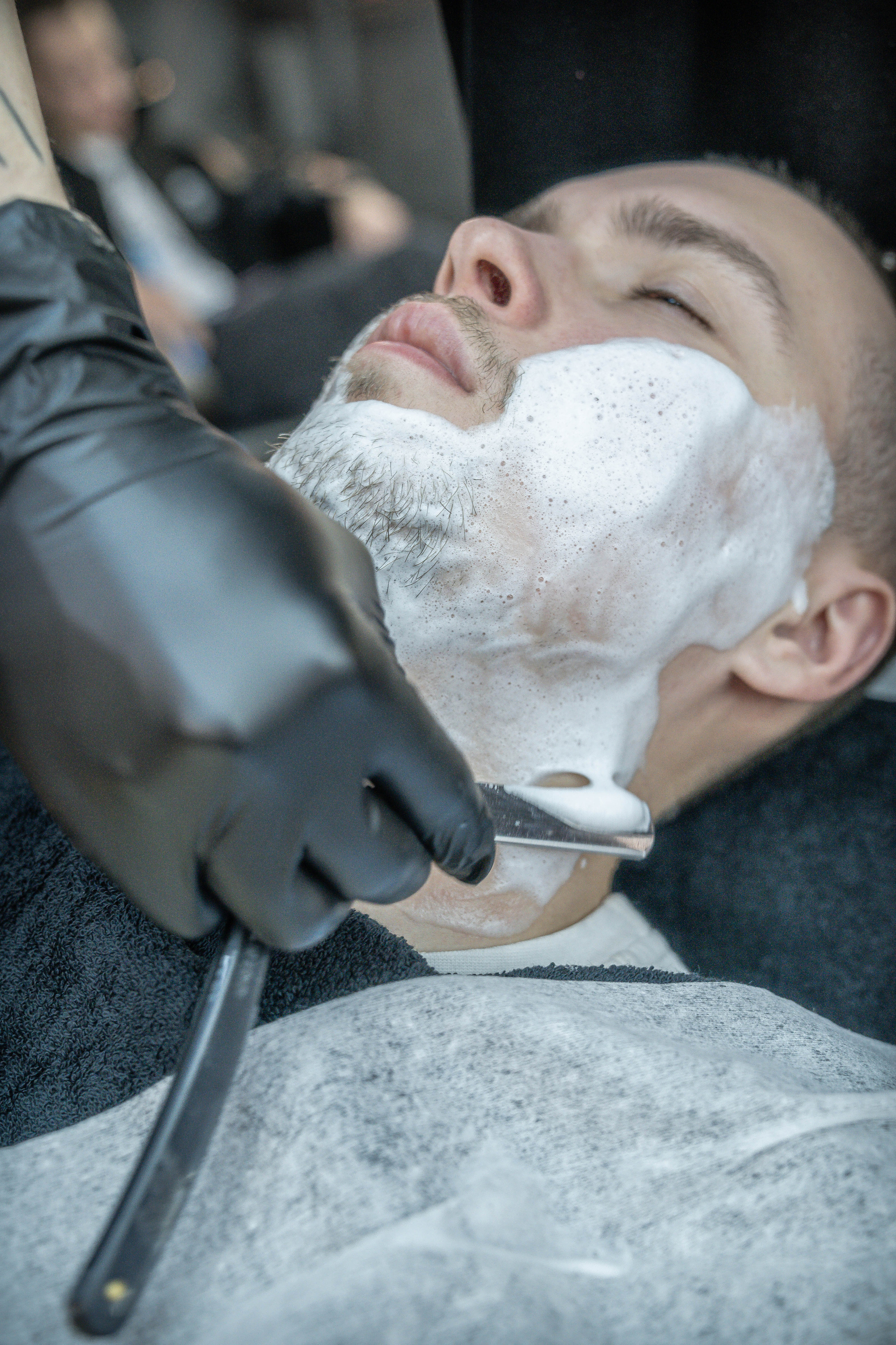 бритьё бритвой в барбершопе