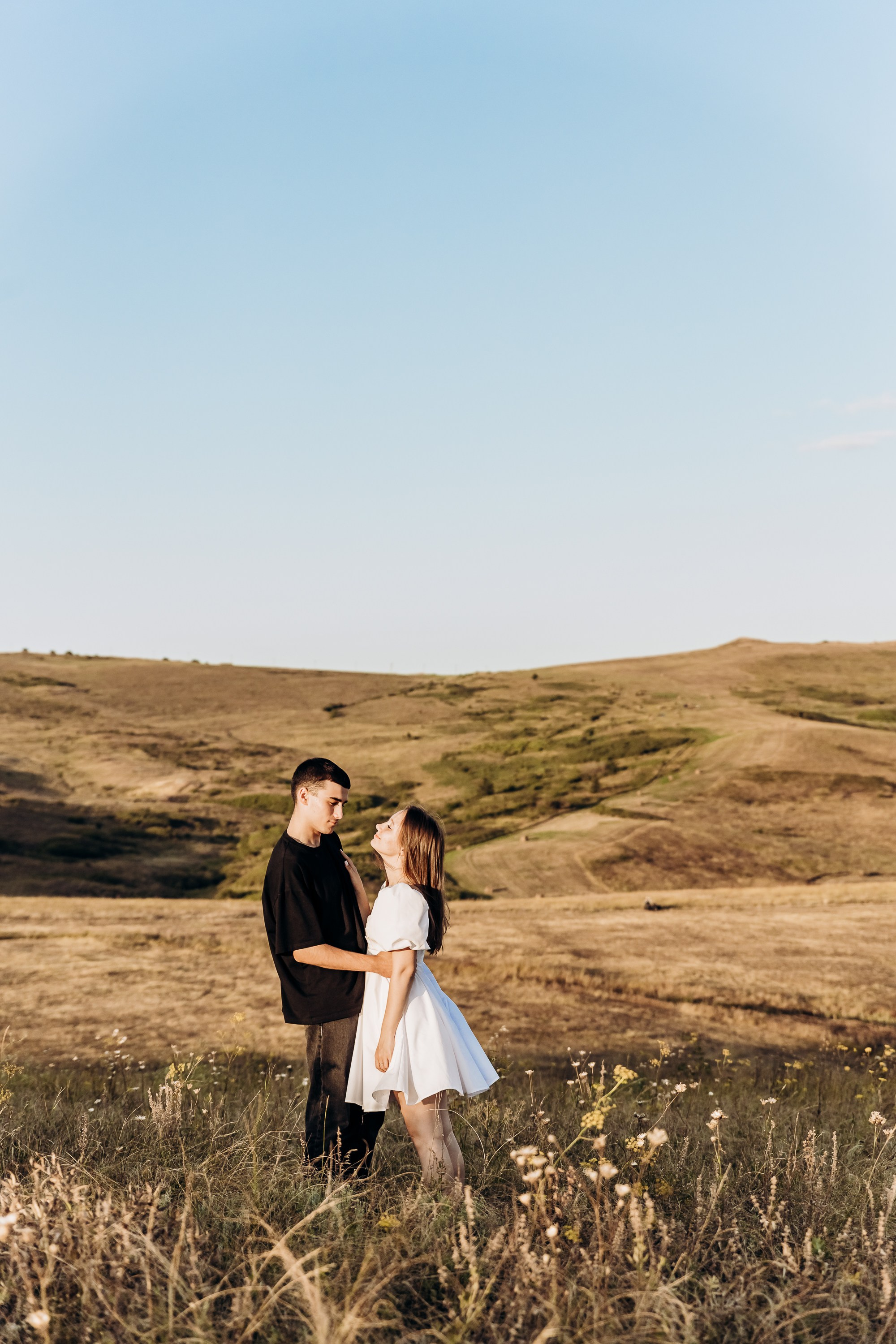 Прижимающаяся пара на пикнике в парке, окруженная зеленью