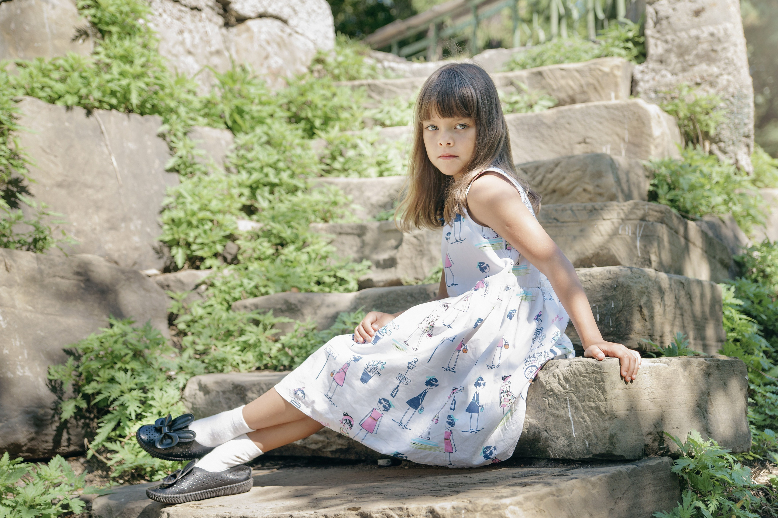 Детская фотосессия летом - девочка сидя на каменной лестнице