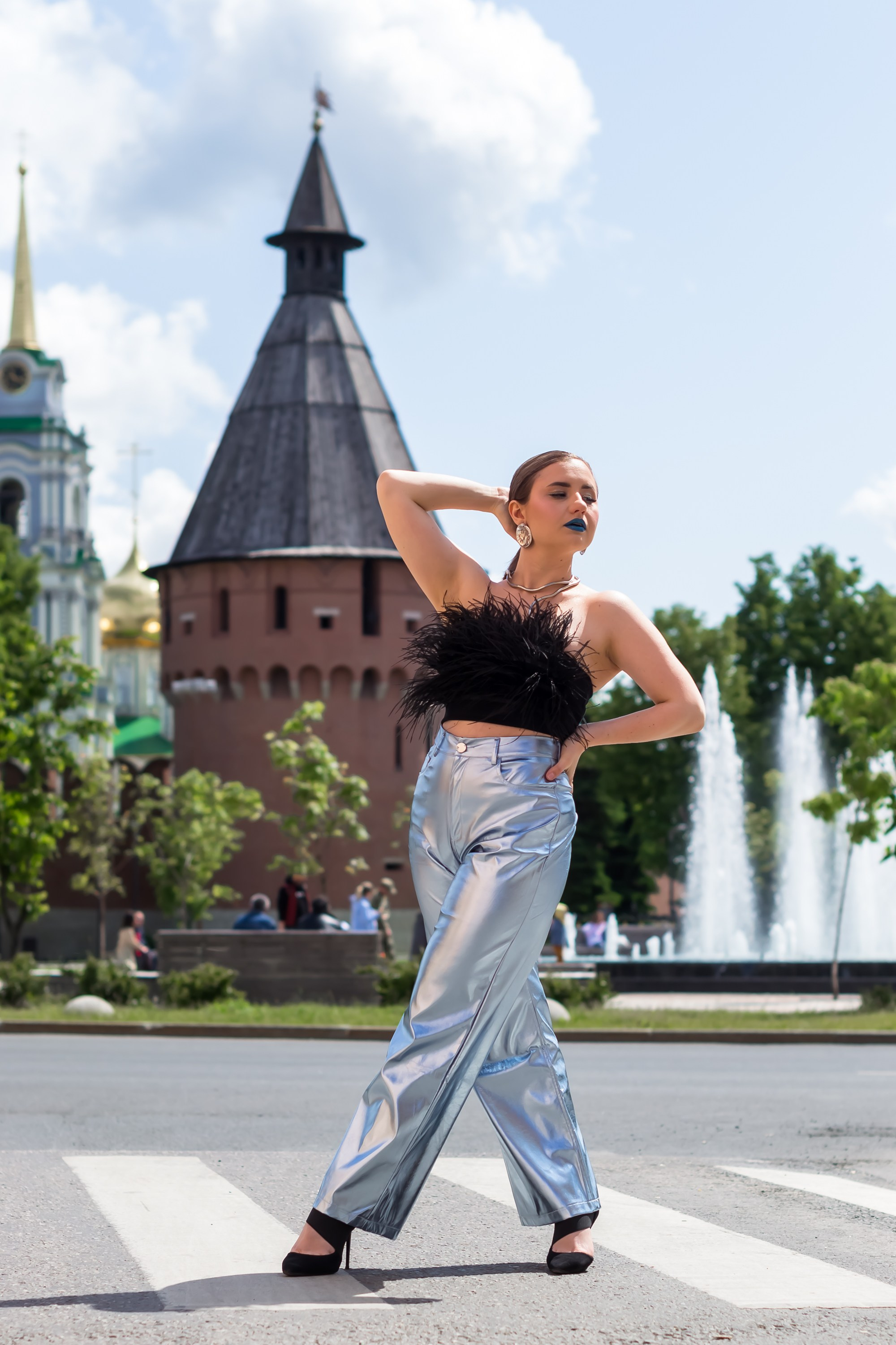 На фотографии девушка стоит на пешеходном переходе.