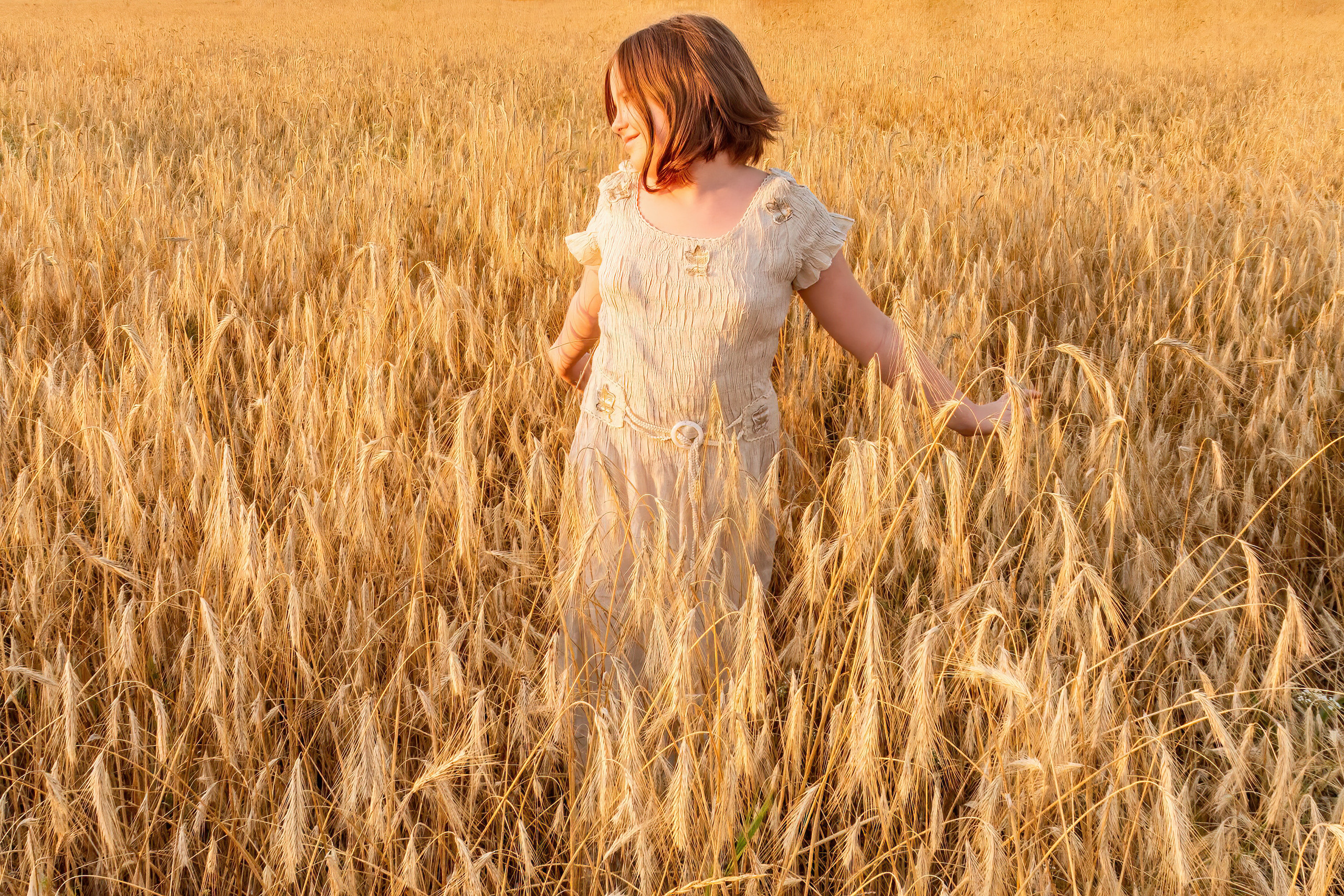 девочка стоит в пшеничном поле