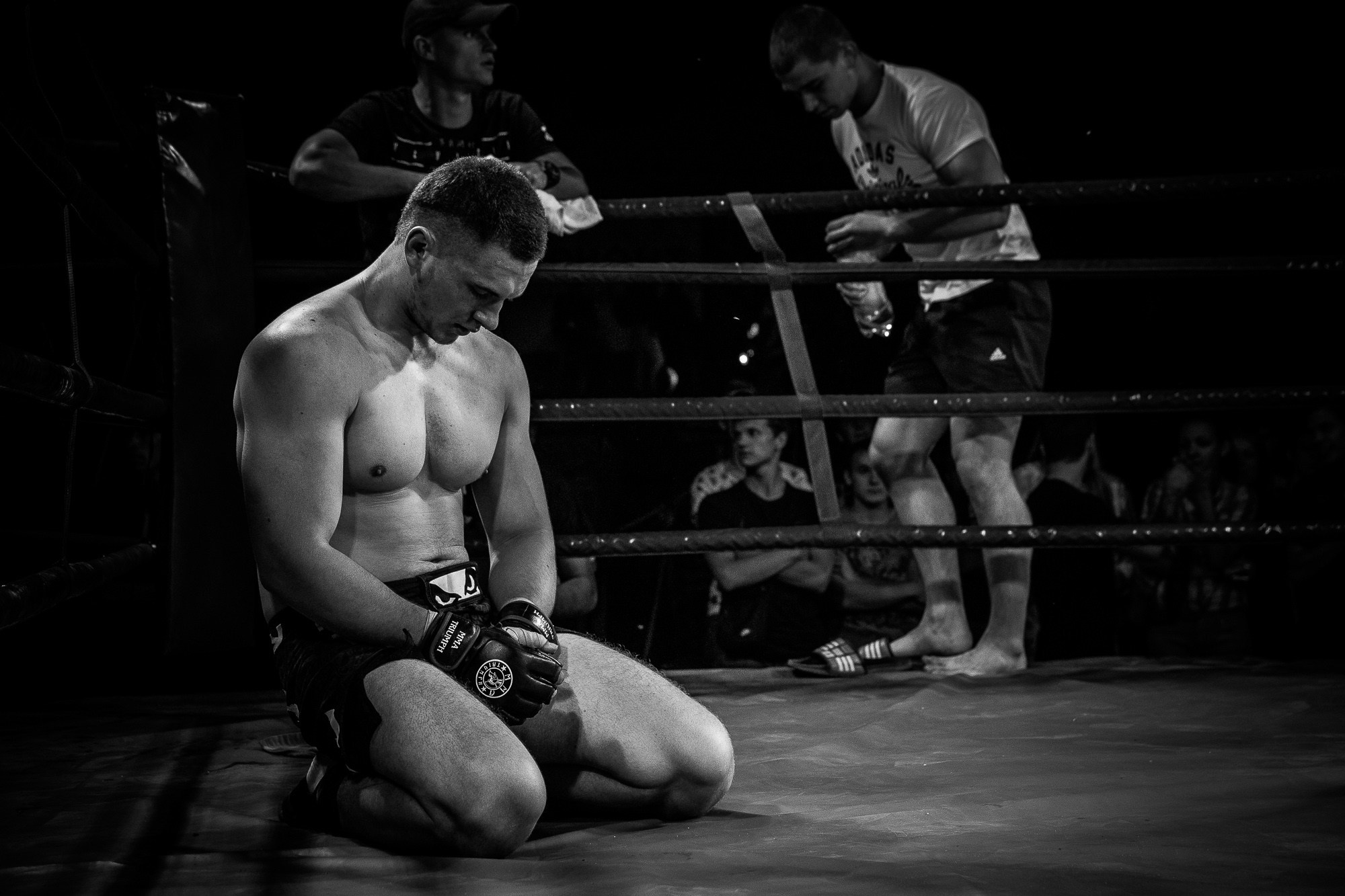 Боец без правил сидит в углу ринга после поражения