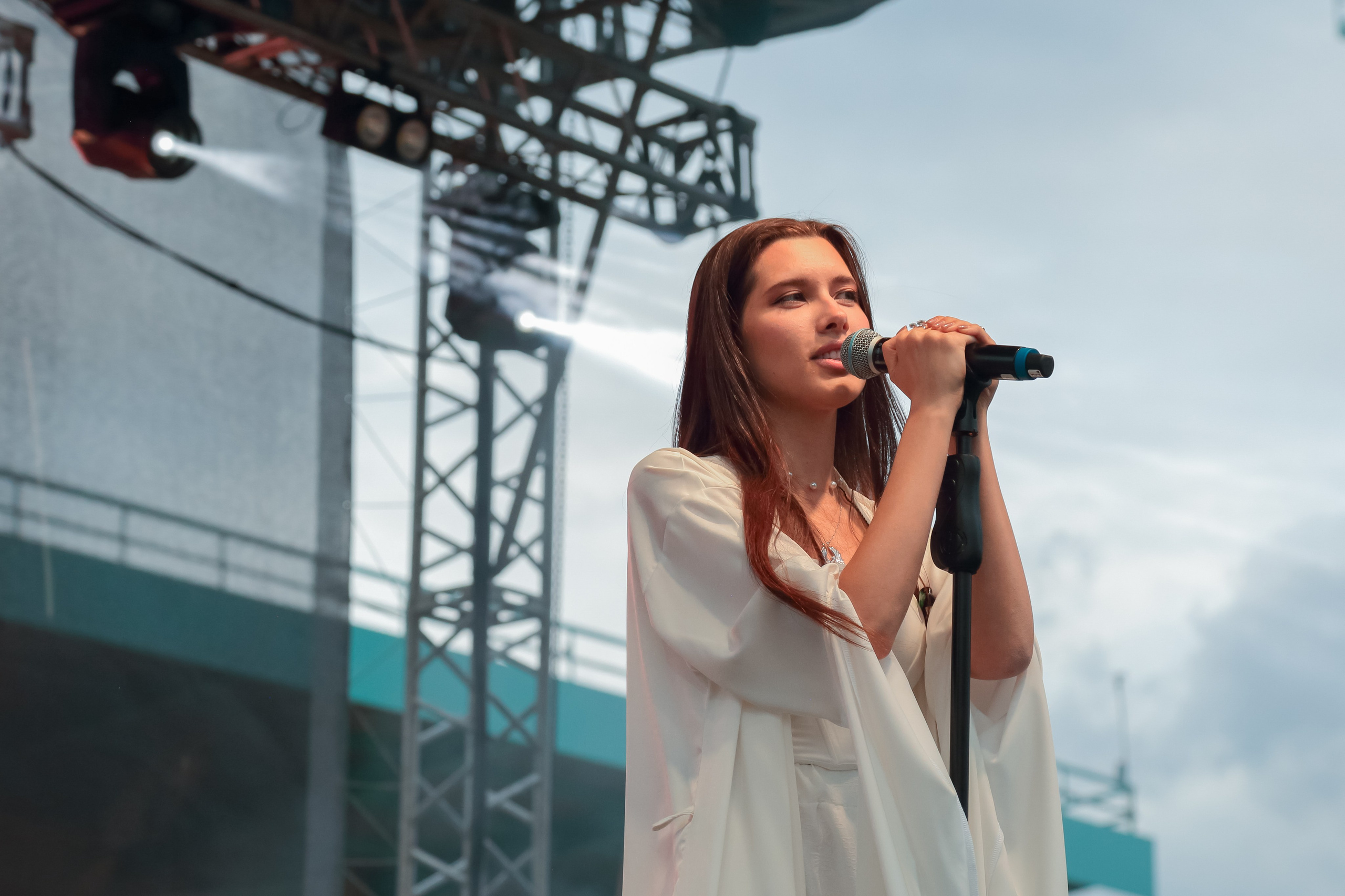 Фотограф в Липецке снимает выступление вокалиста на праздничном концерте.