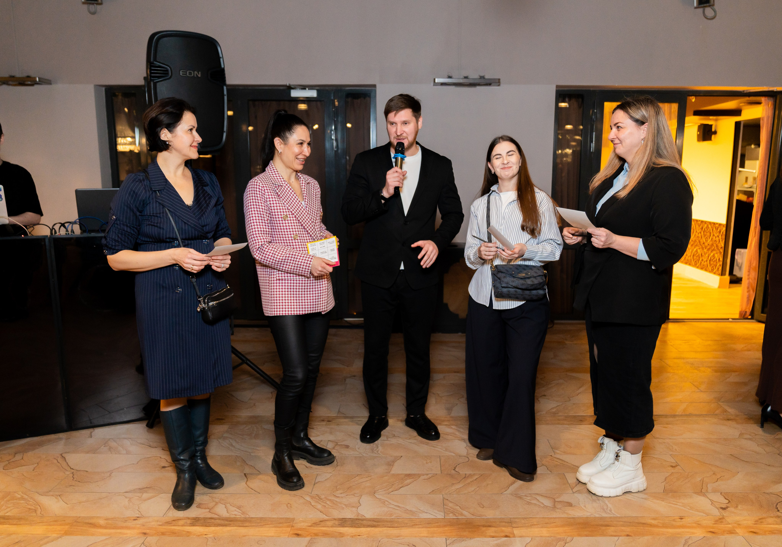 Ведущий с микрофоном и участницы розыгрыша на корпоративе в Radisson Sonya. Фотограф Евгений Мальцев, evrednix.ru.