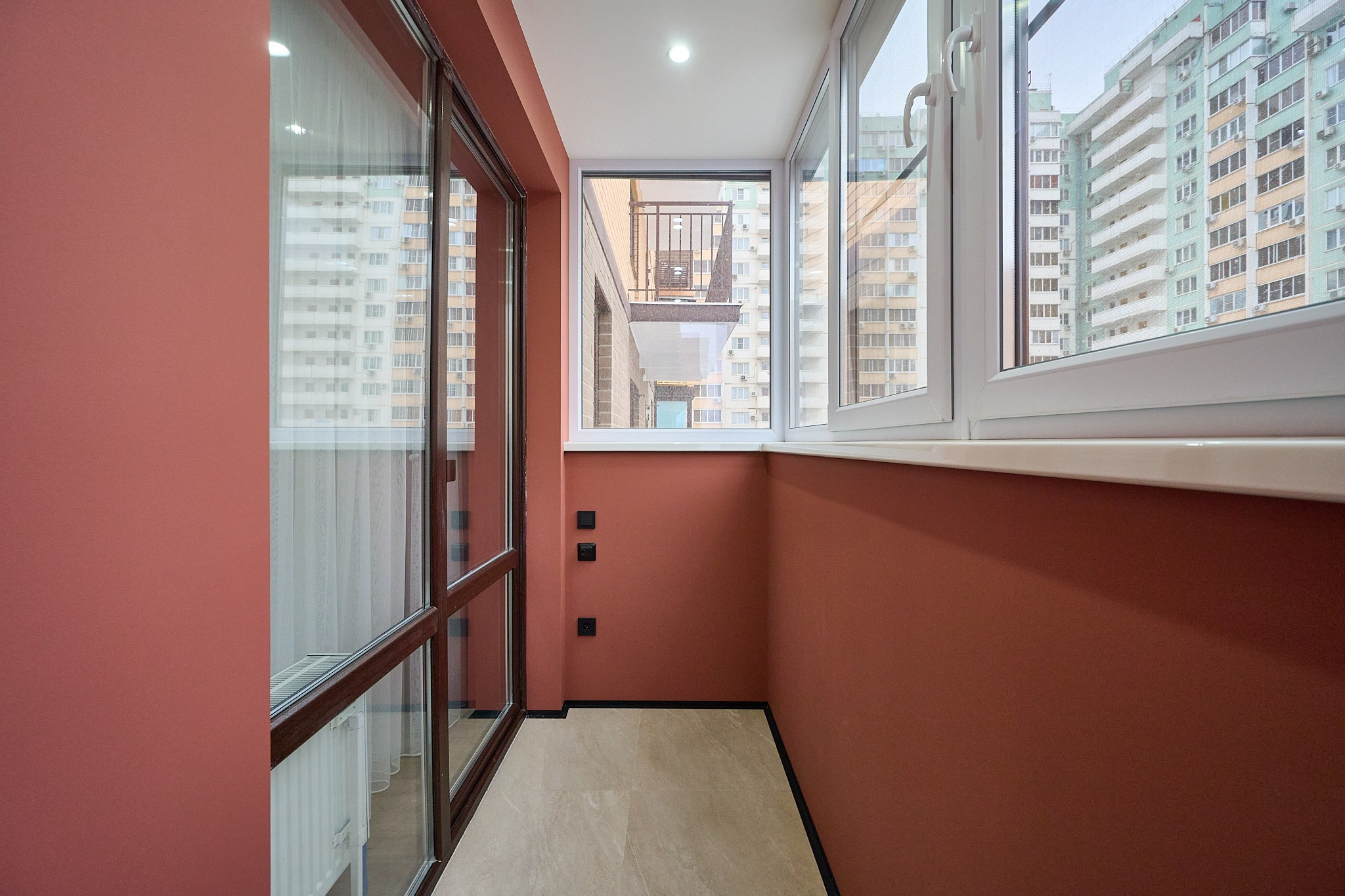 балкон в красном цвете и стеклянными дверями 