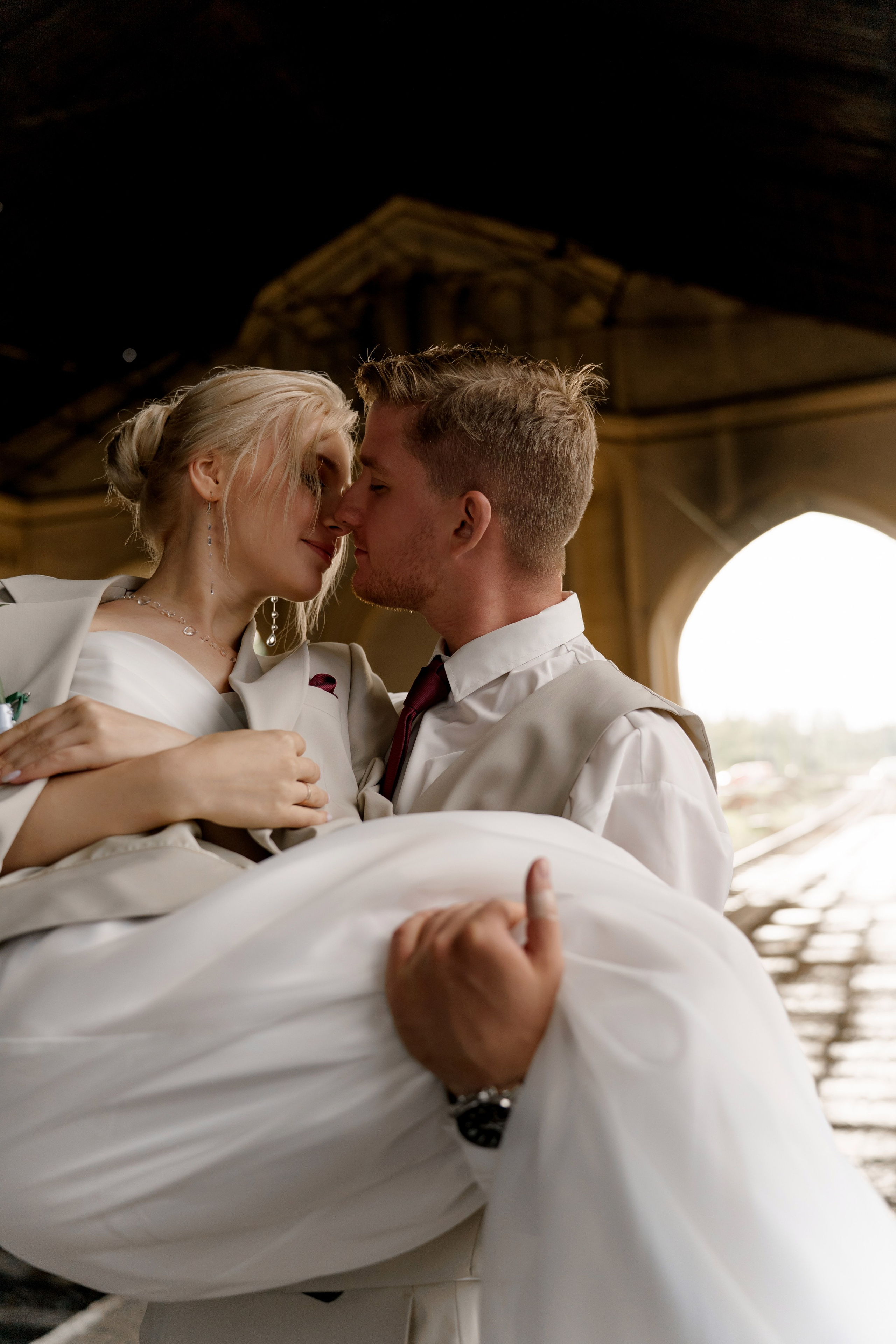 Свадьба в Санкт-Петербурге, фотосессия на прогулке, жених несет невесту на руках на вокзале.