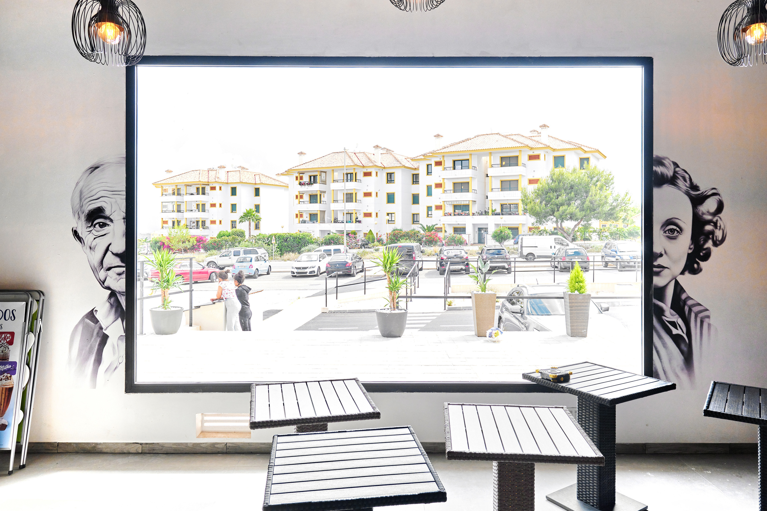 Mural artístico impreso y graffiti en la pared de una cafetería y tienda en España