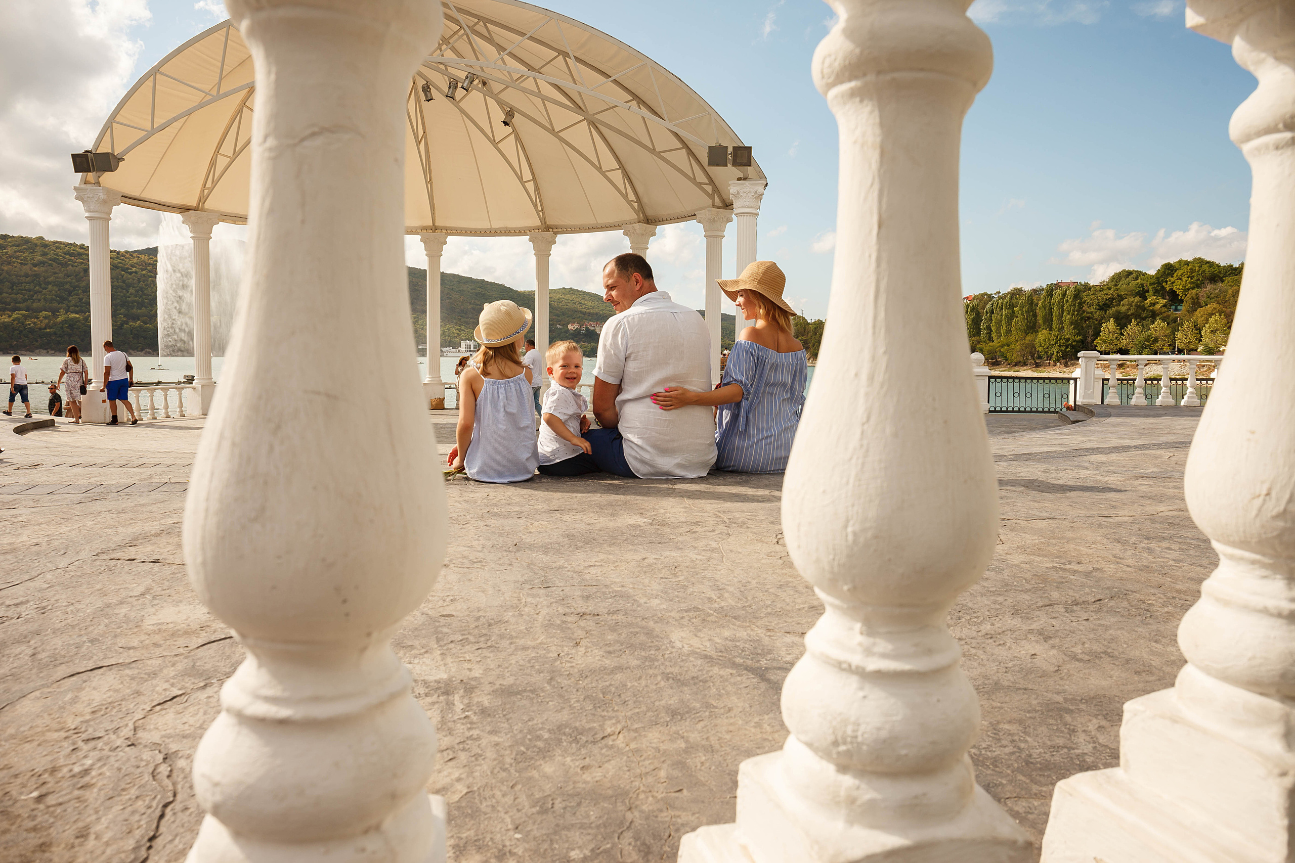 семья из 4 человек сидит на набережной в абрау