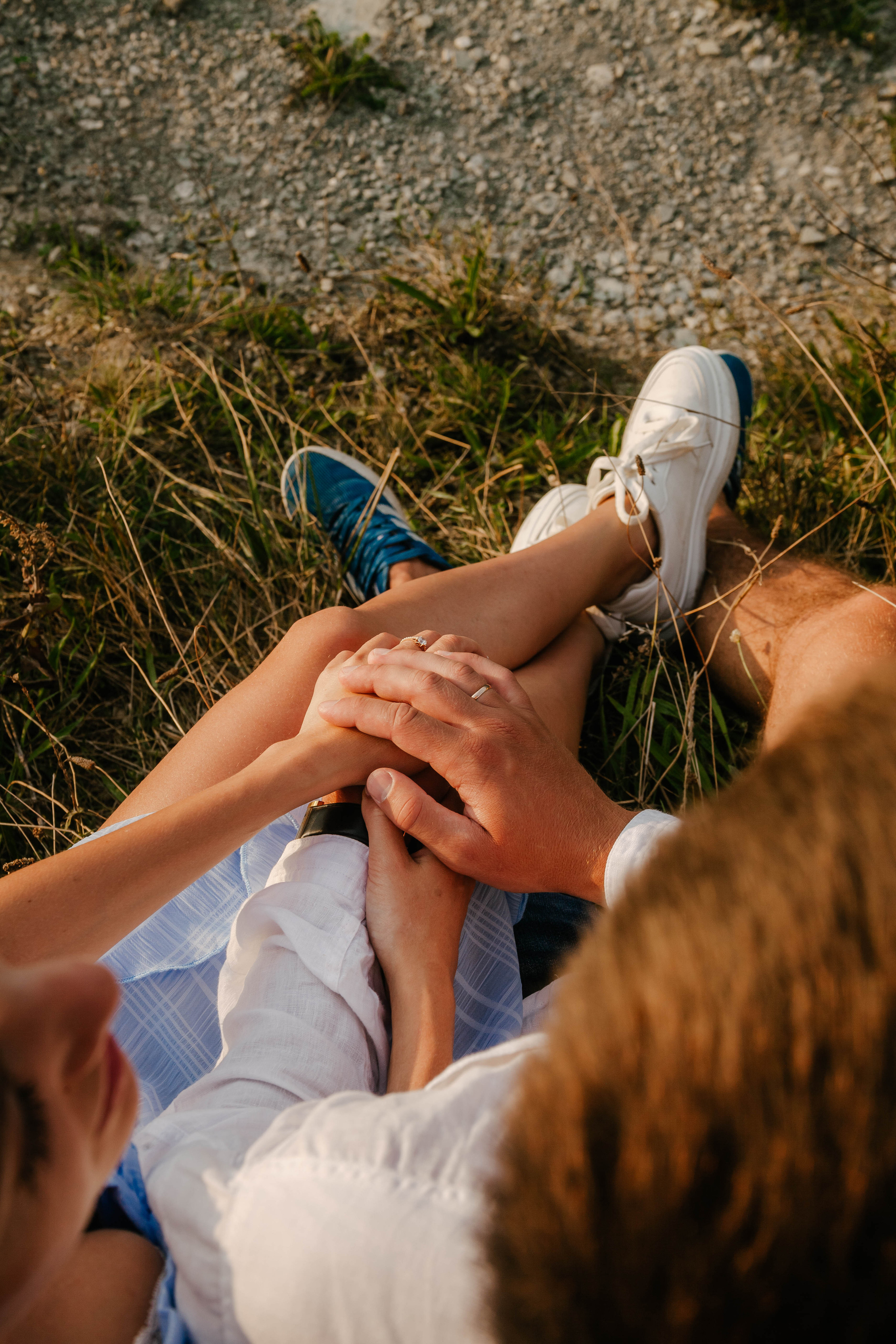 крупным планом руки жениха и невесты и их ноги переплетены