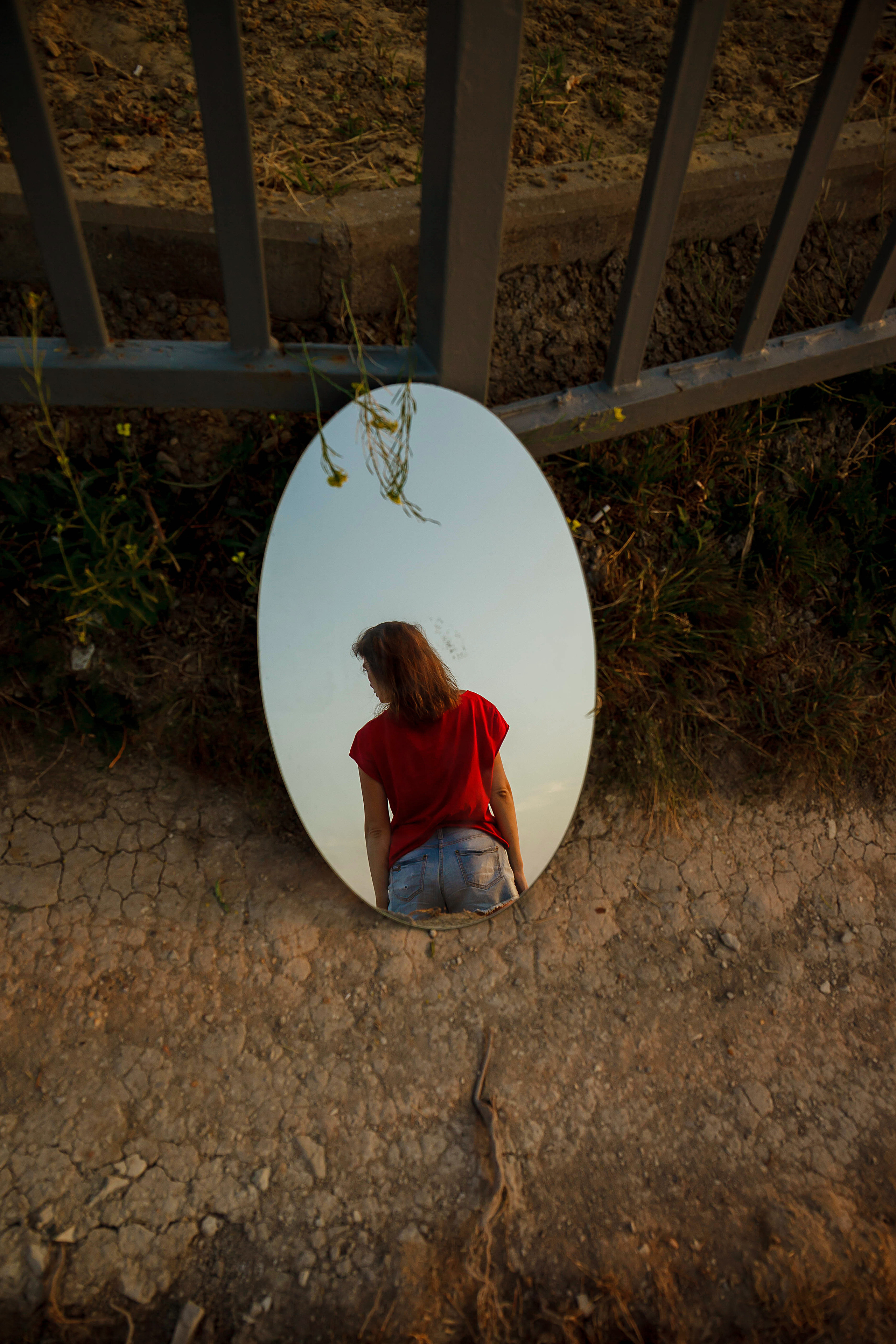 силуэт девушки стоящей спиной отражается в зеркале