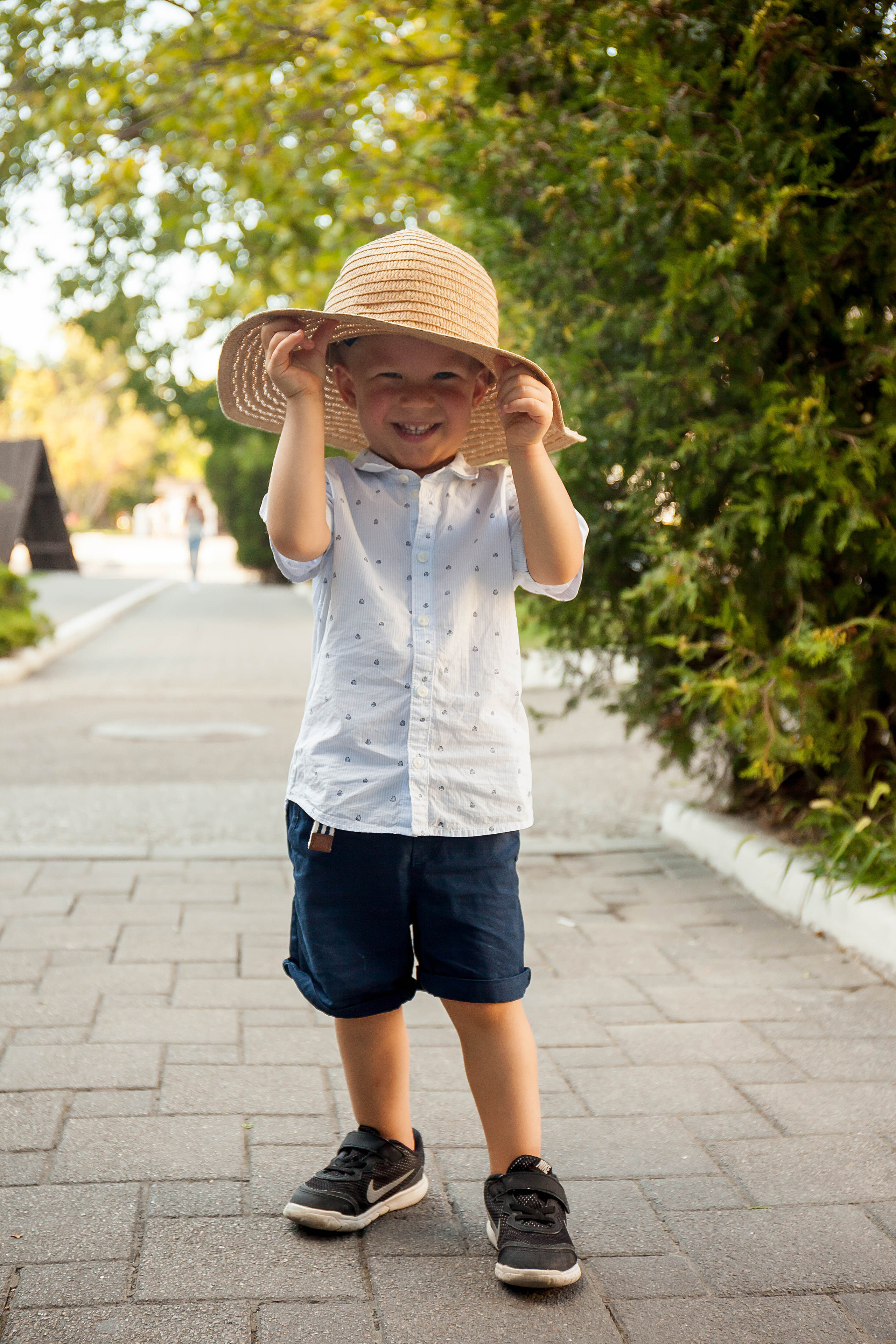 мальчик надел мамину шляпу и улыбается