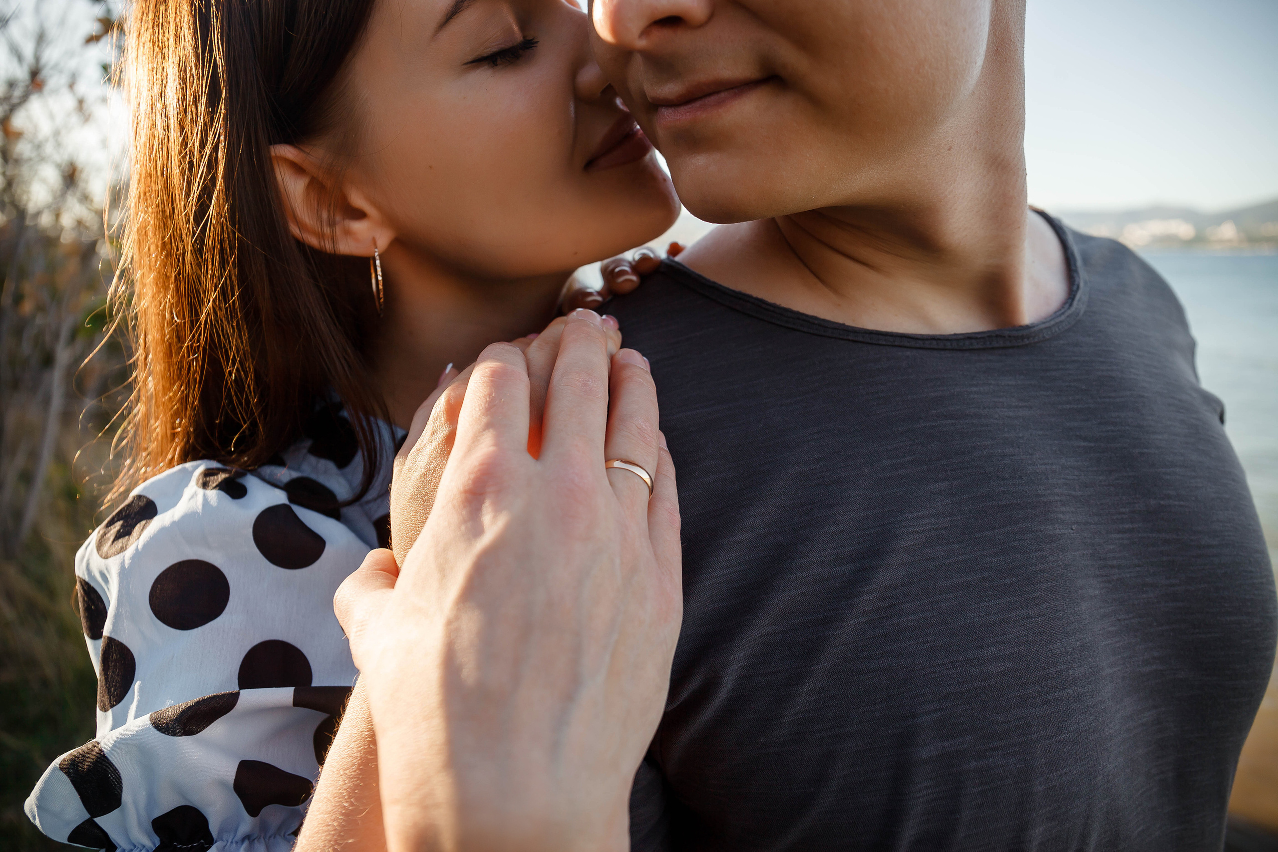 крупным планом руки девушки целующей своего парня в щеку