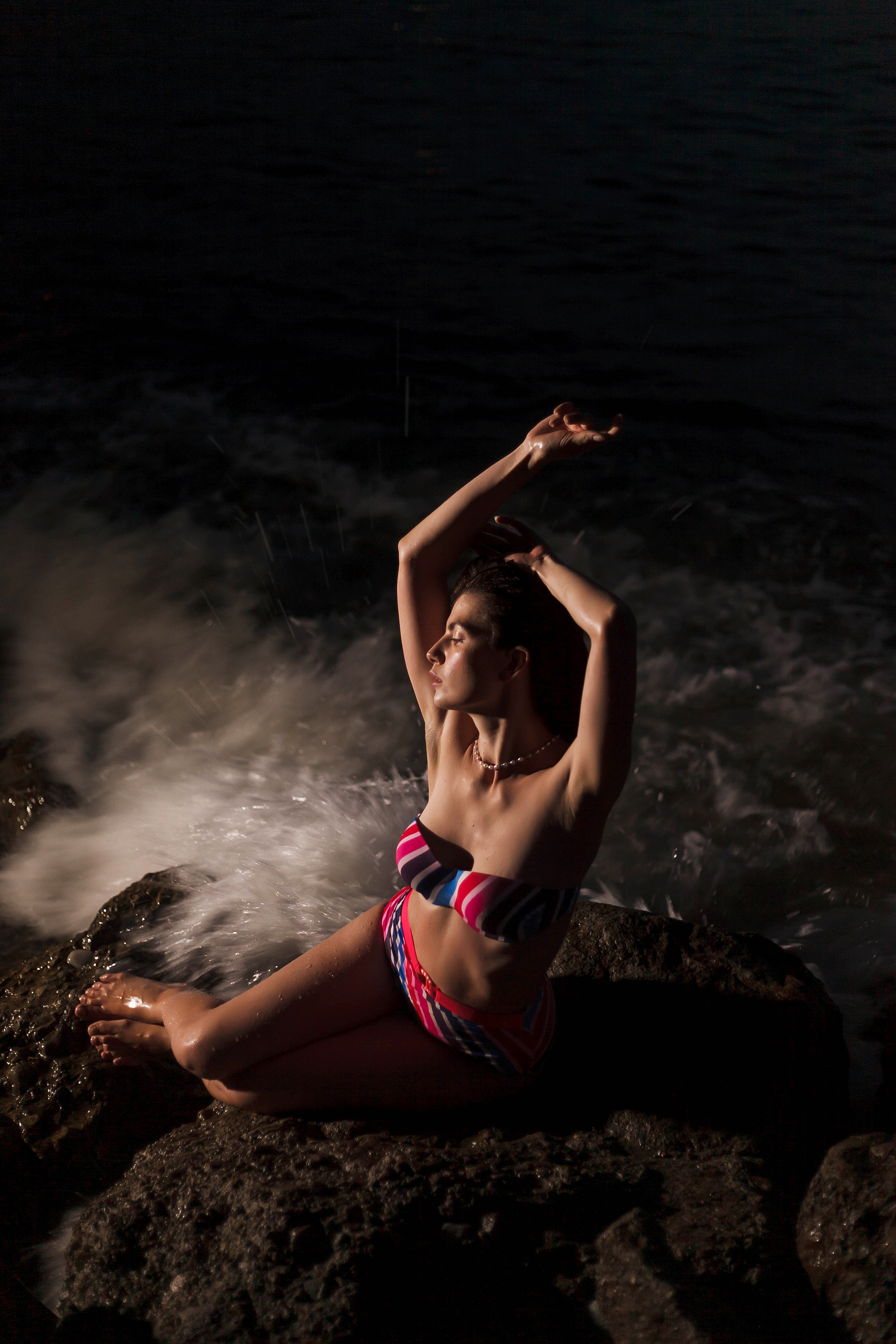 девушка сидит на камне  ночью на пляже геленджика