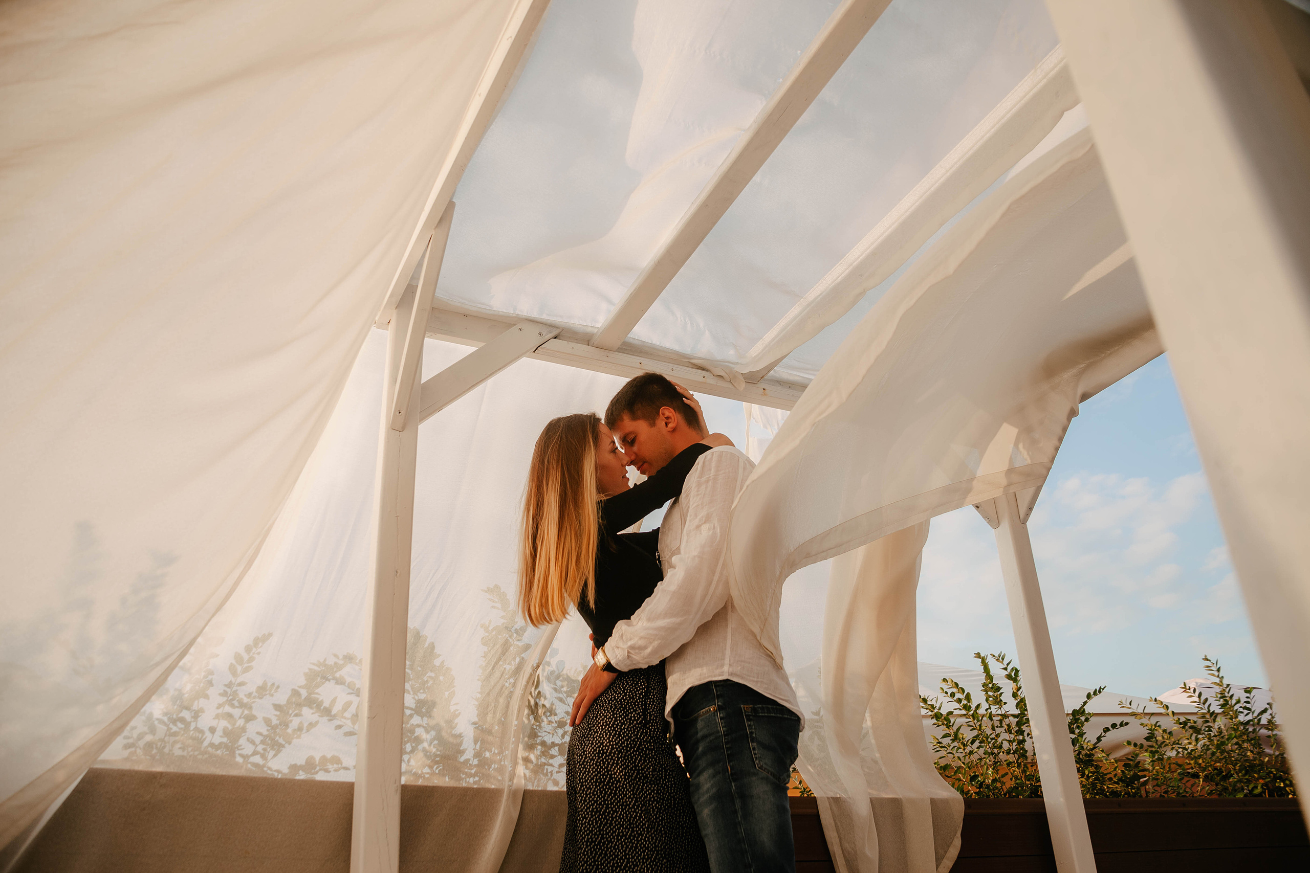 пара обнимается в пляжном шатре ветер развивает ткань