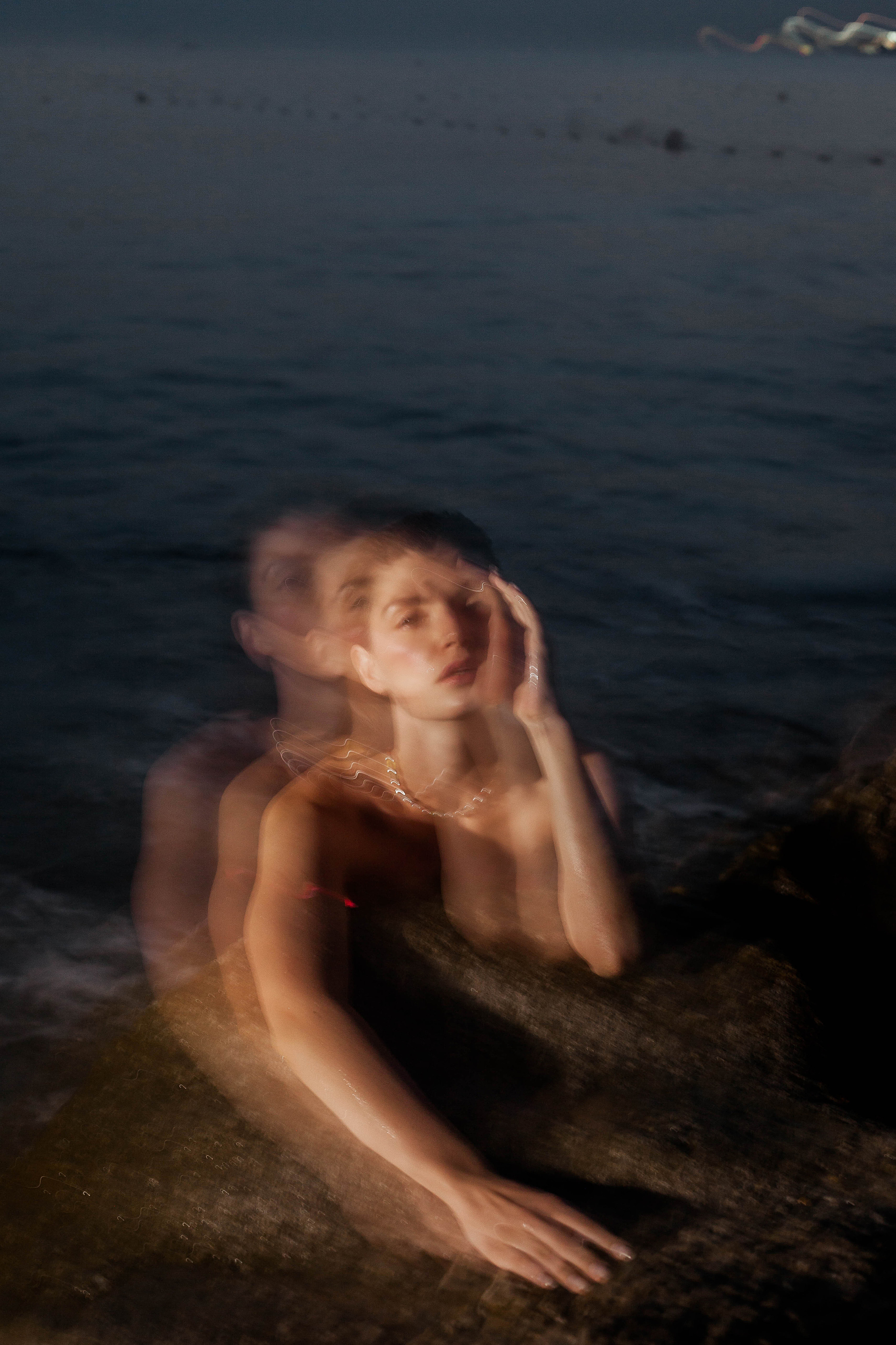 девушка лежит на камнях в темноте