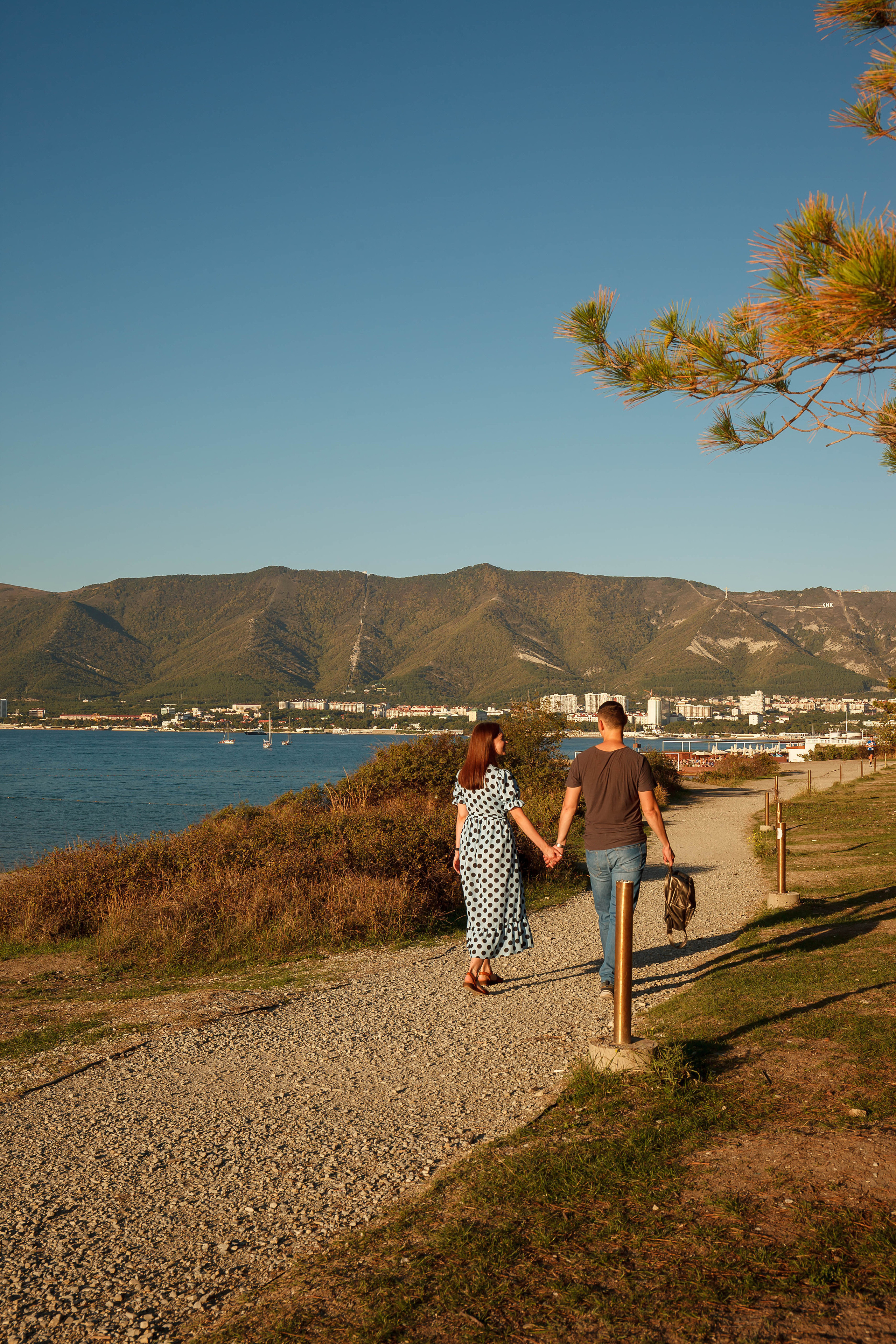 пара прогуливается на толстом мысе вдоль моря