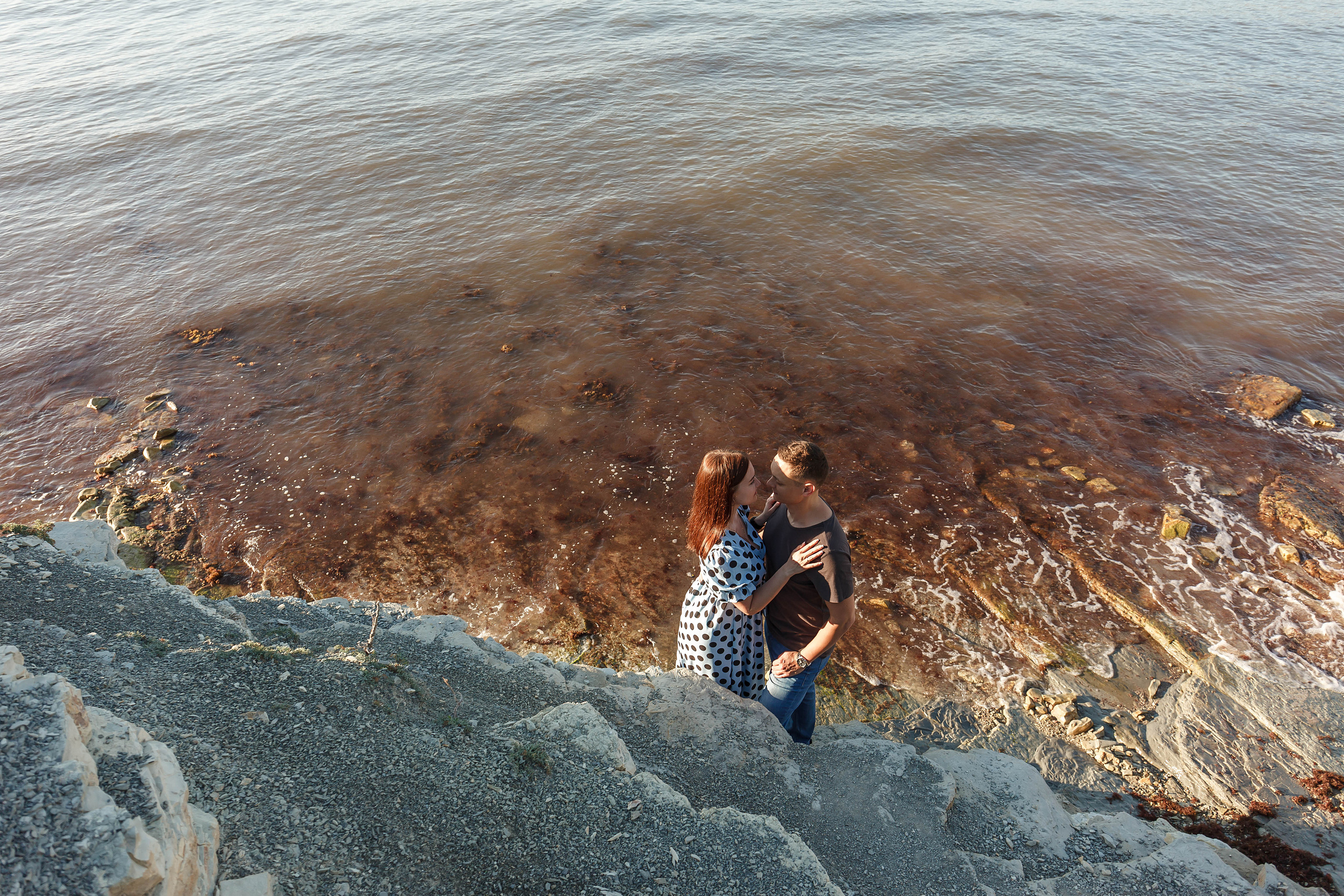 красивый вид со скалы на черное море и пару влюбленных