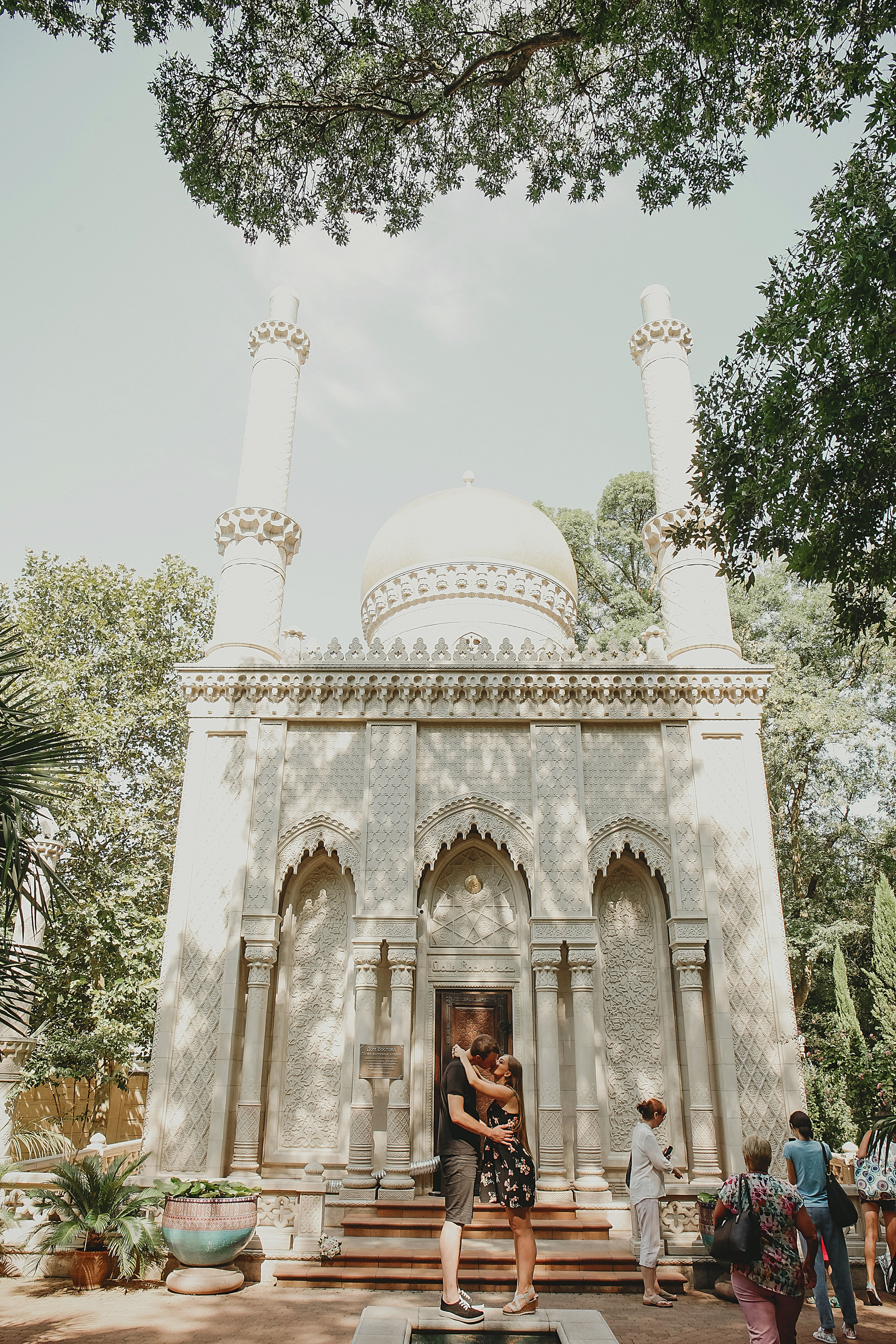 пара стоит обнявшись возле восточного музея в старом парке в кабардинке