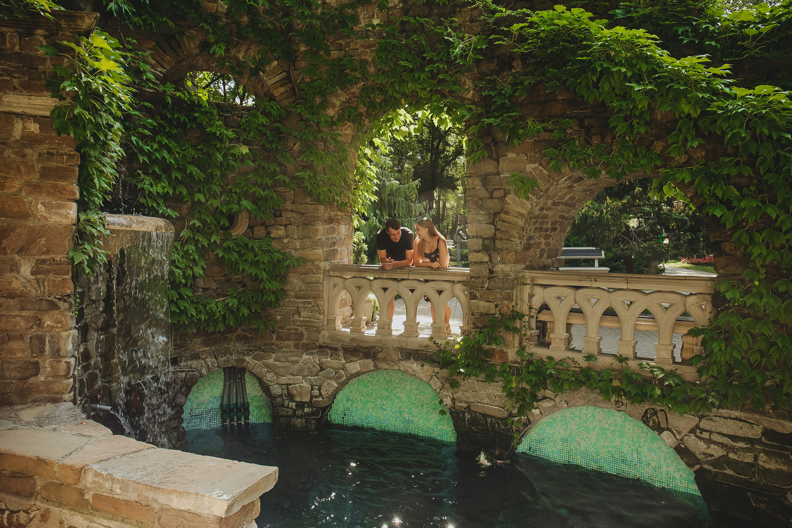 красивый арочный пруд с цветущим плющом в старом парке