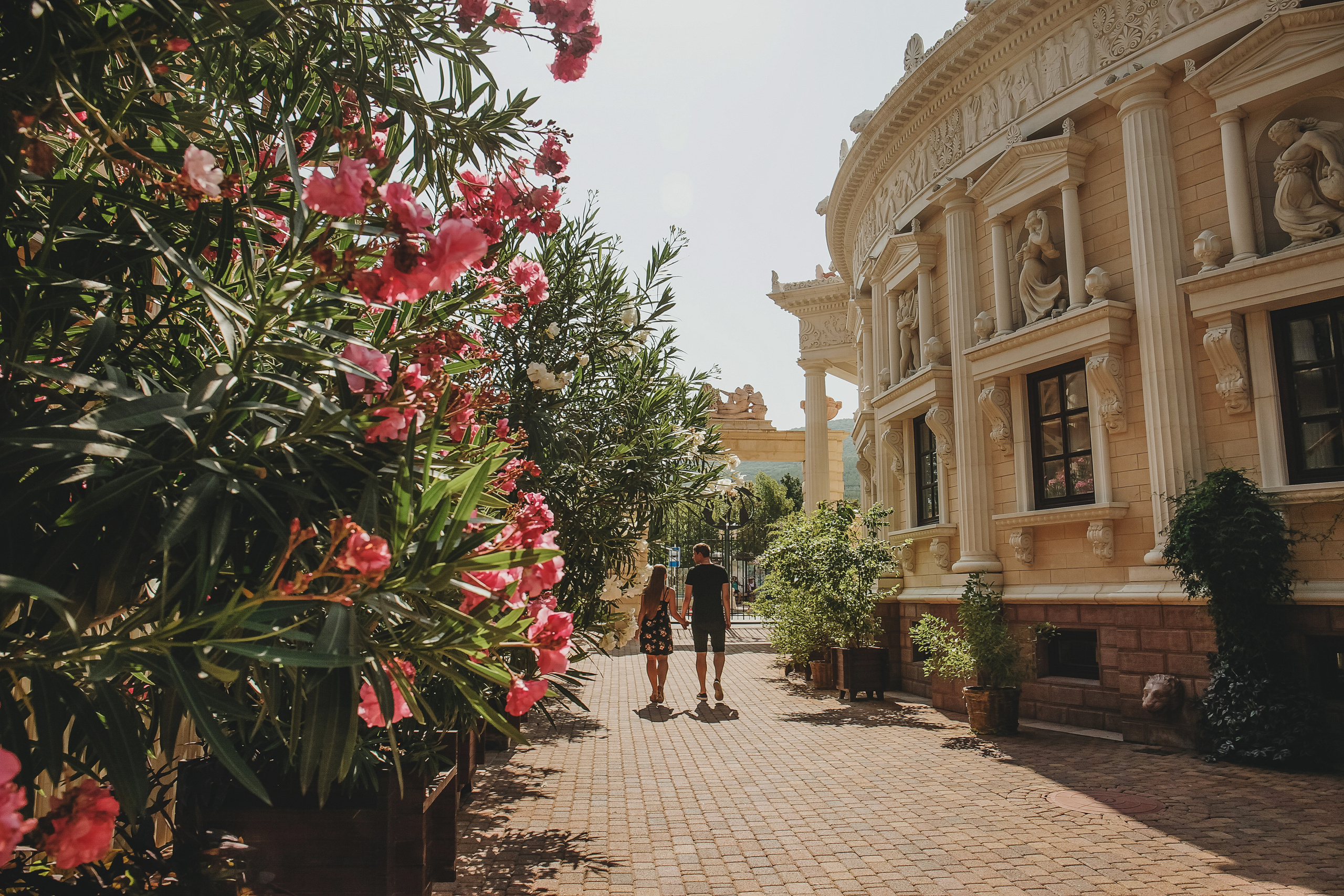 парень с девушкой гуляют по старом парку возле театра