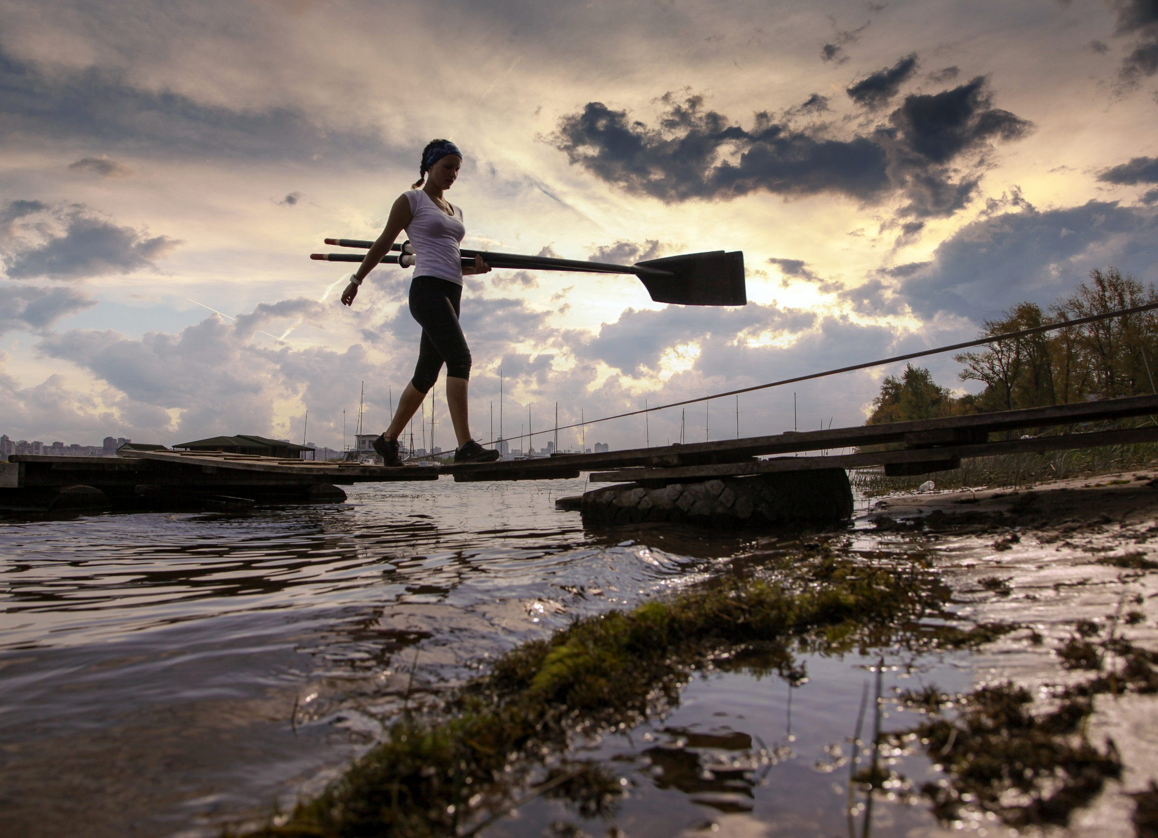 Девушка с веслом идёт на берег