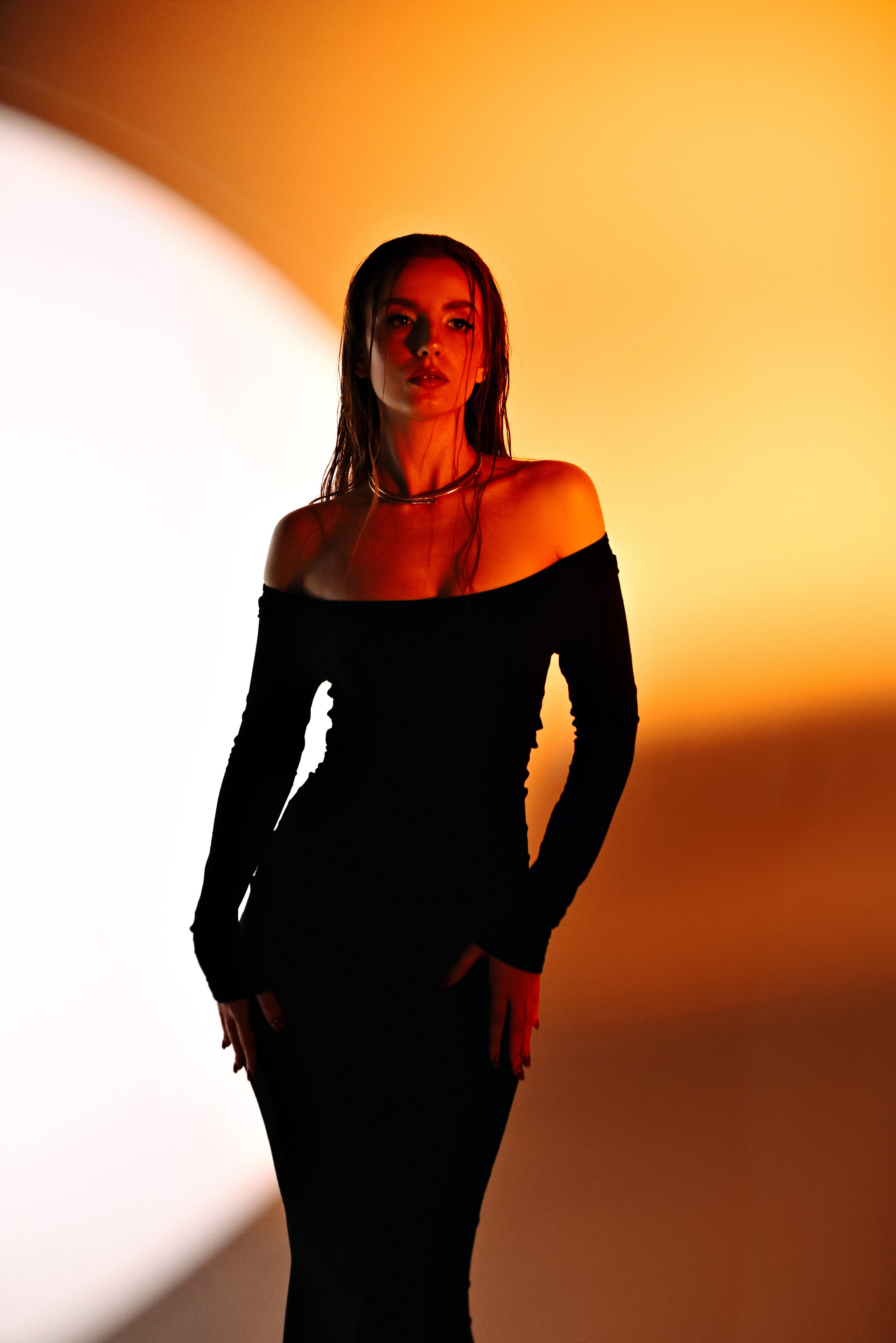 Студийная съёмка девушки в черном платье с ярким цветным фоном