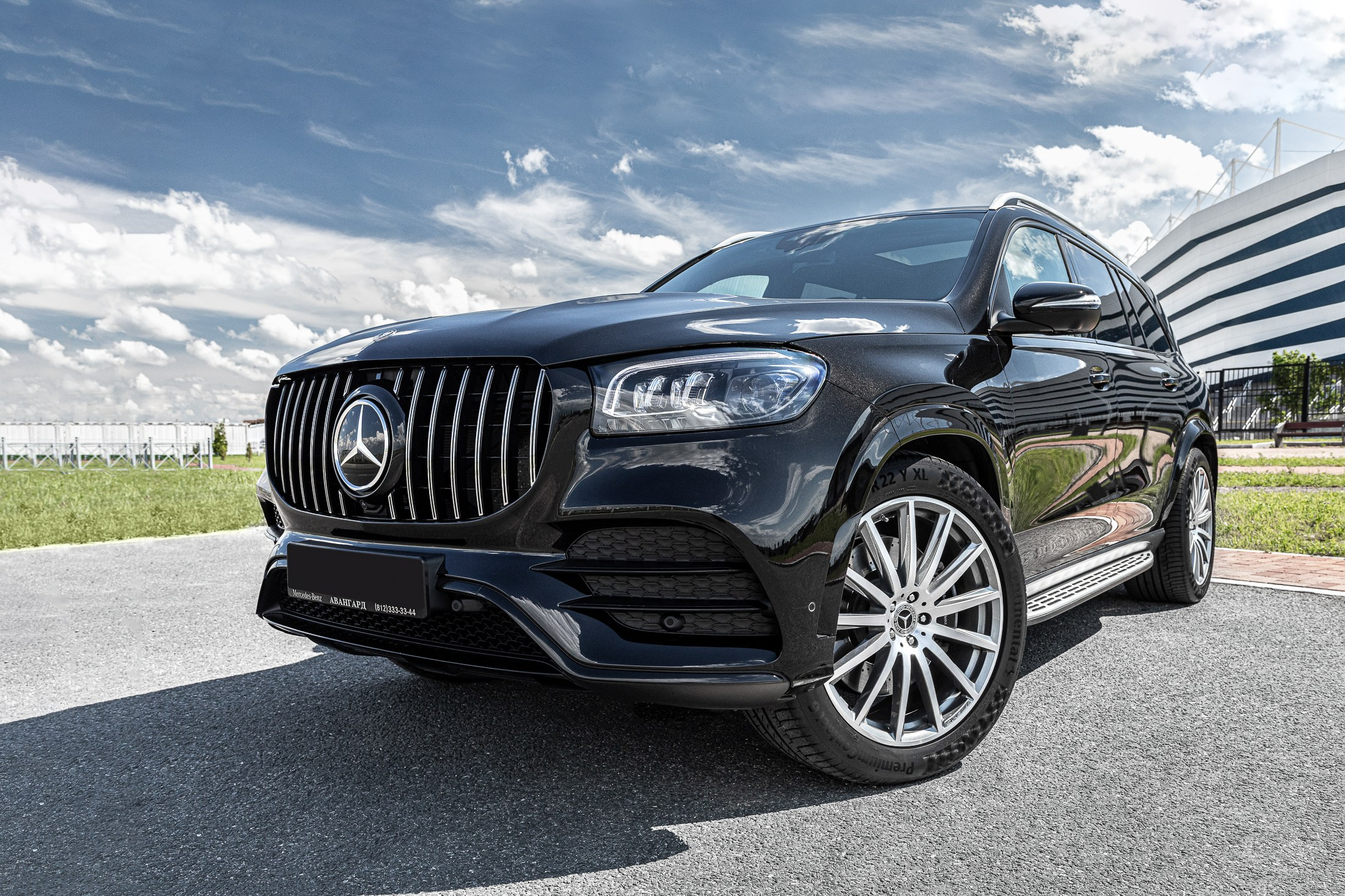 Черная машина Mercedes на фоне стадиона на улице в Калининграде.