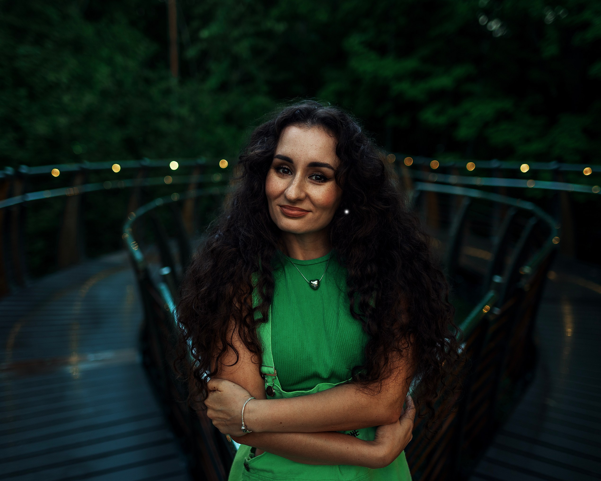 Девушка в платье стоит на фоне зелени