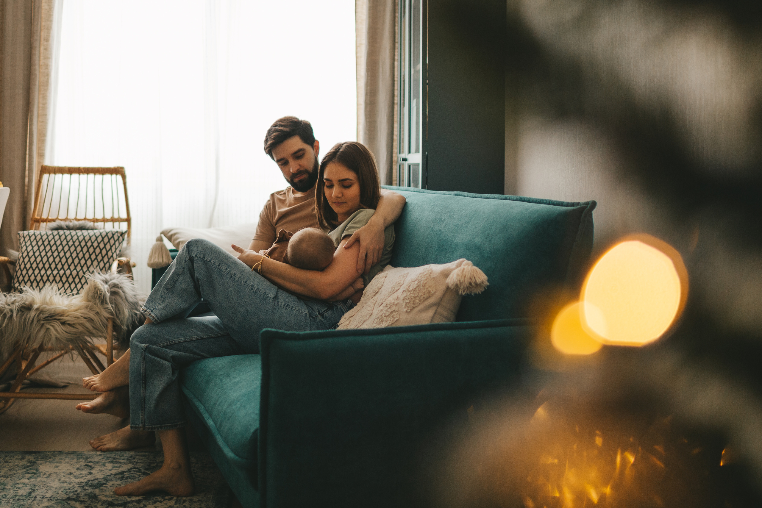 Семья возле ёлки. Мама кормит малыша, папа сидит рядом