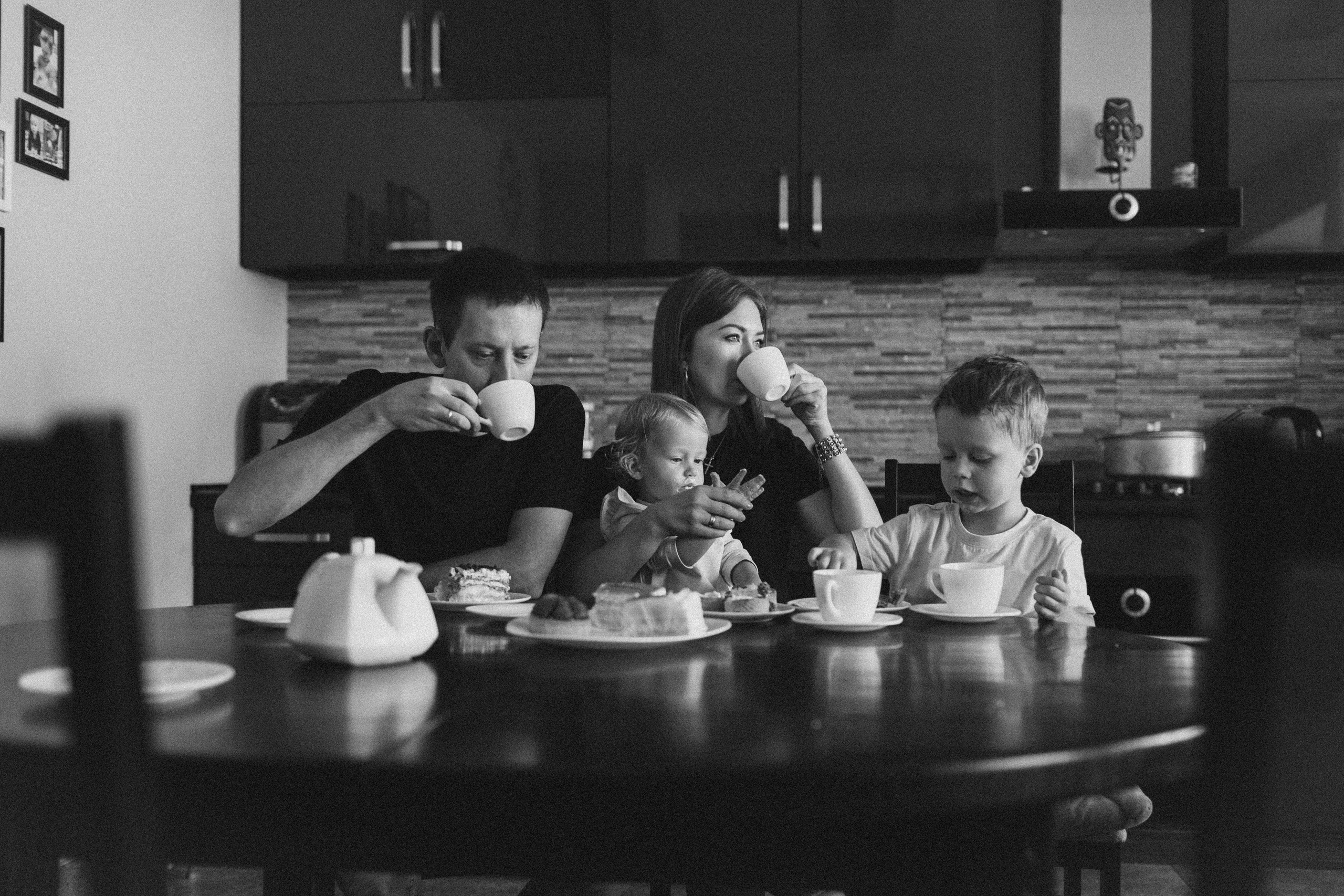 черно-белое фото, семья сидит на кухне за столом и пьет чай