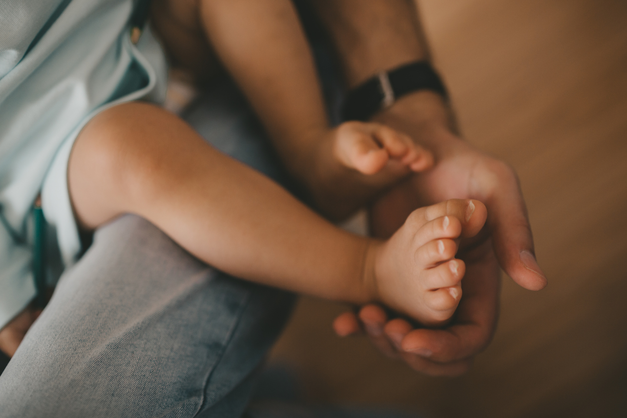 папа держит ножки ребенка в своих руках