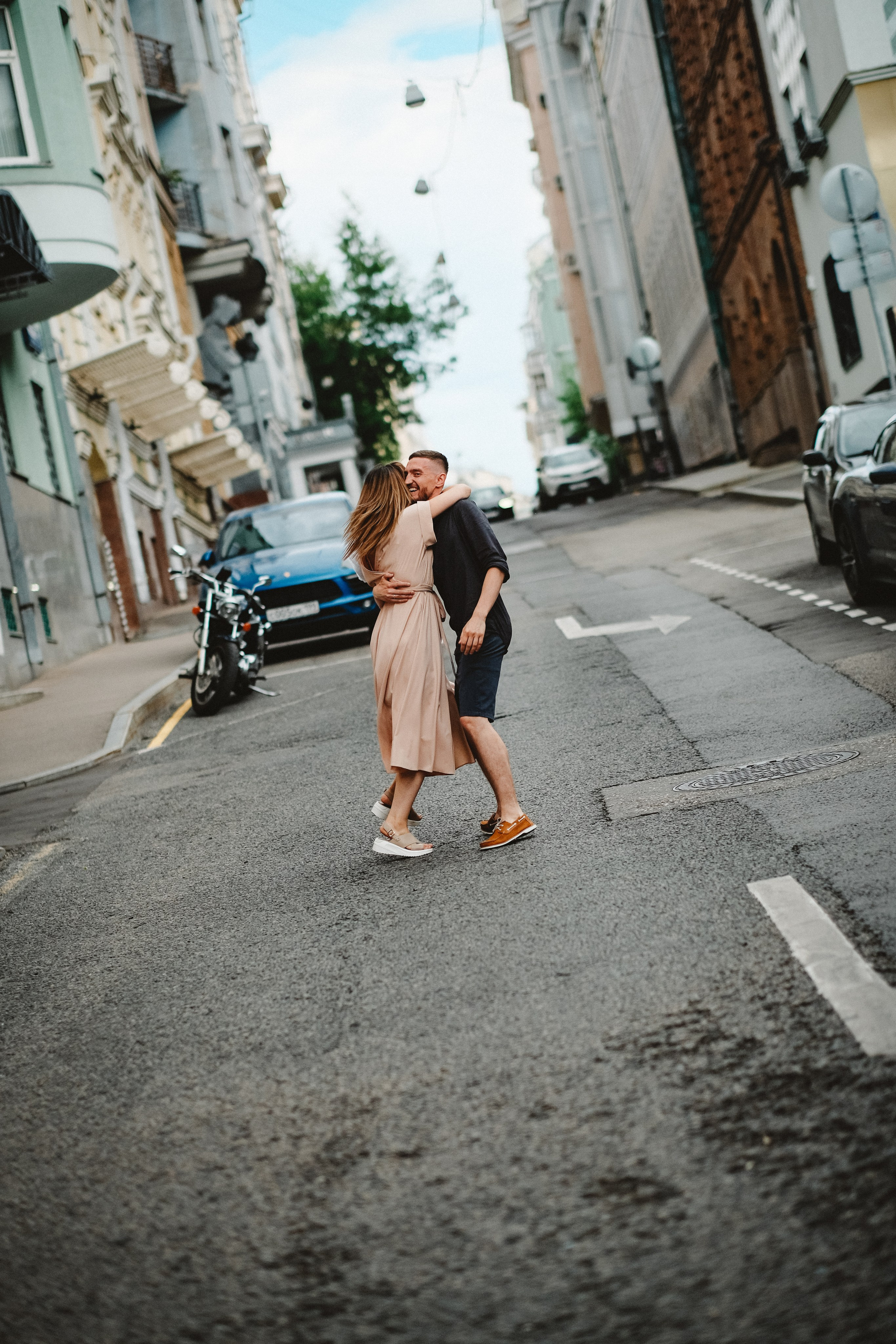 Возлюбленные обнимаются на тихой улочке Москвы.