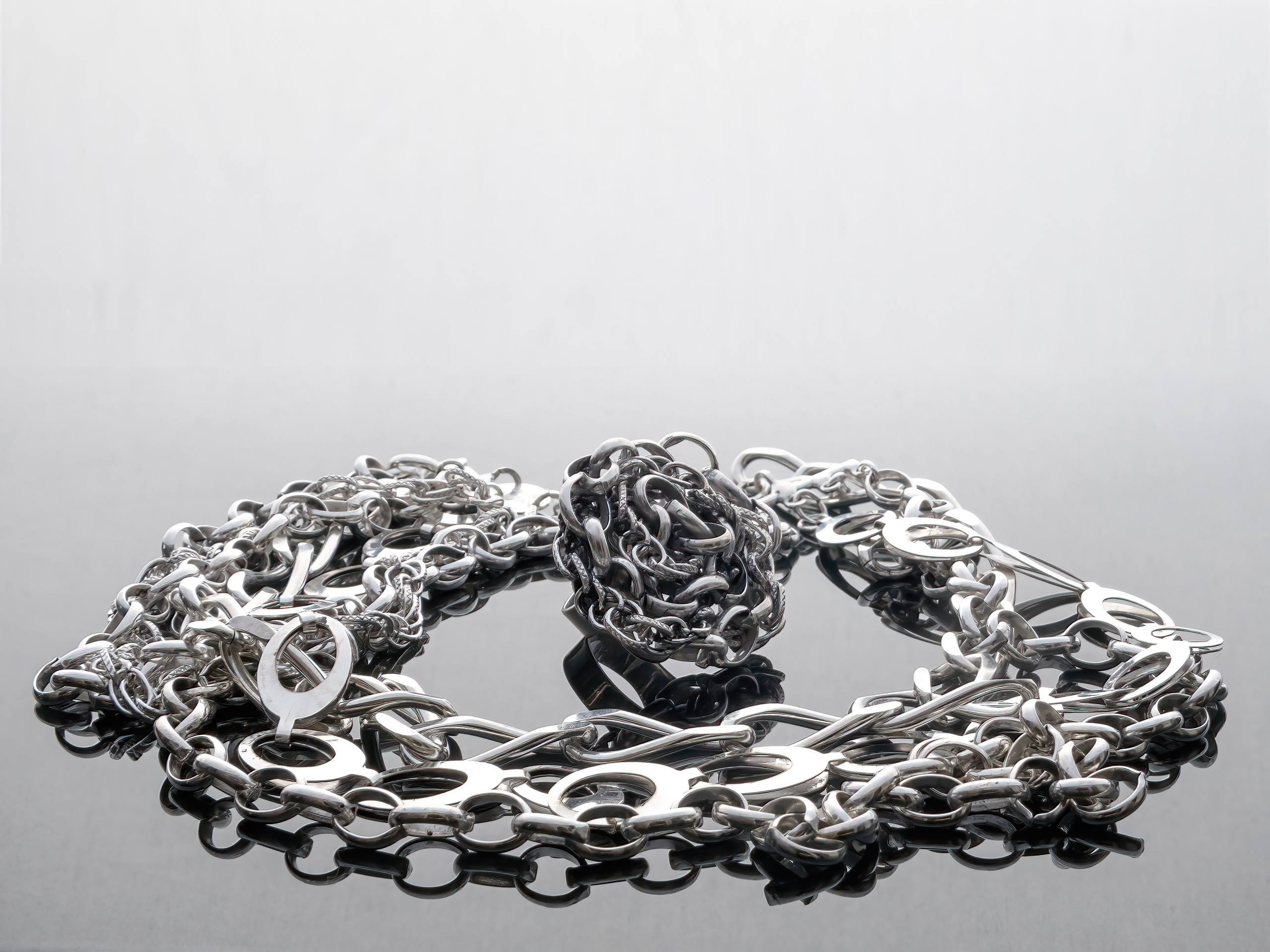 комплект кольцо и цепь на темном стекле с отражением