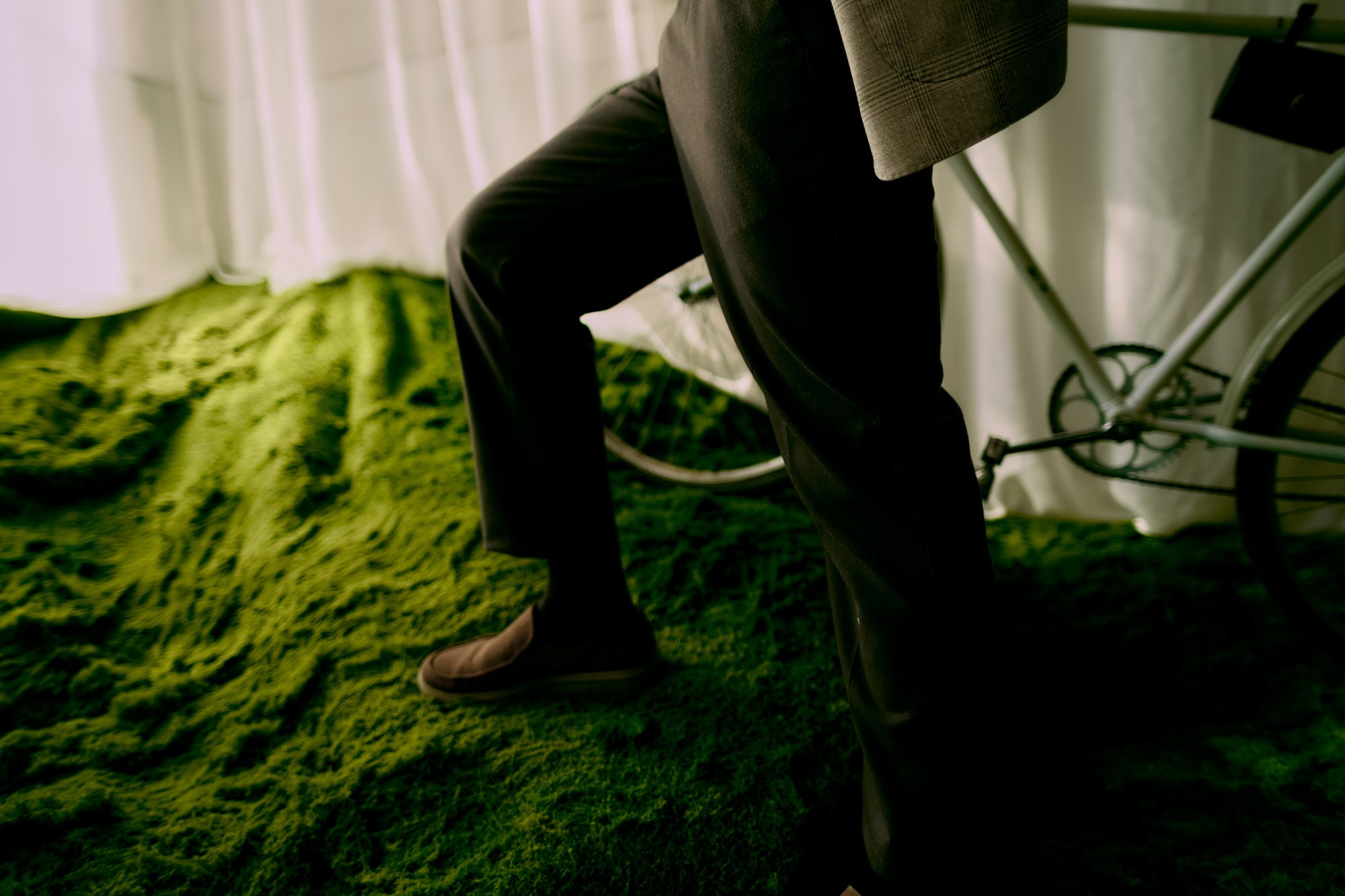 Сюрреалистичный кадр: мужские ноги «идут» по зеленому мху на потолке. Студия Рояль Тюмень