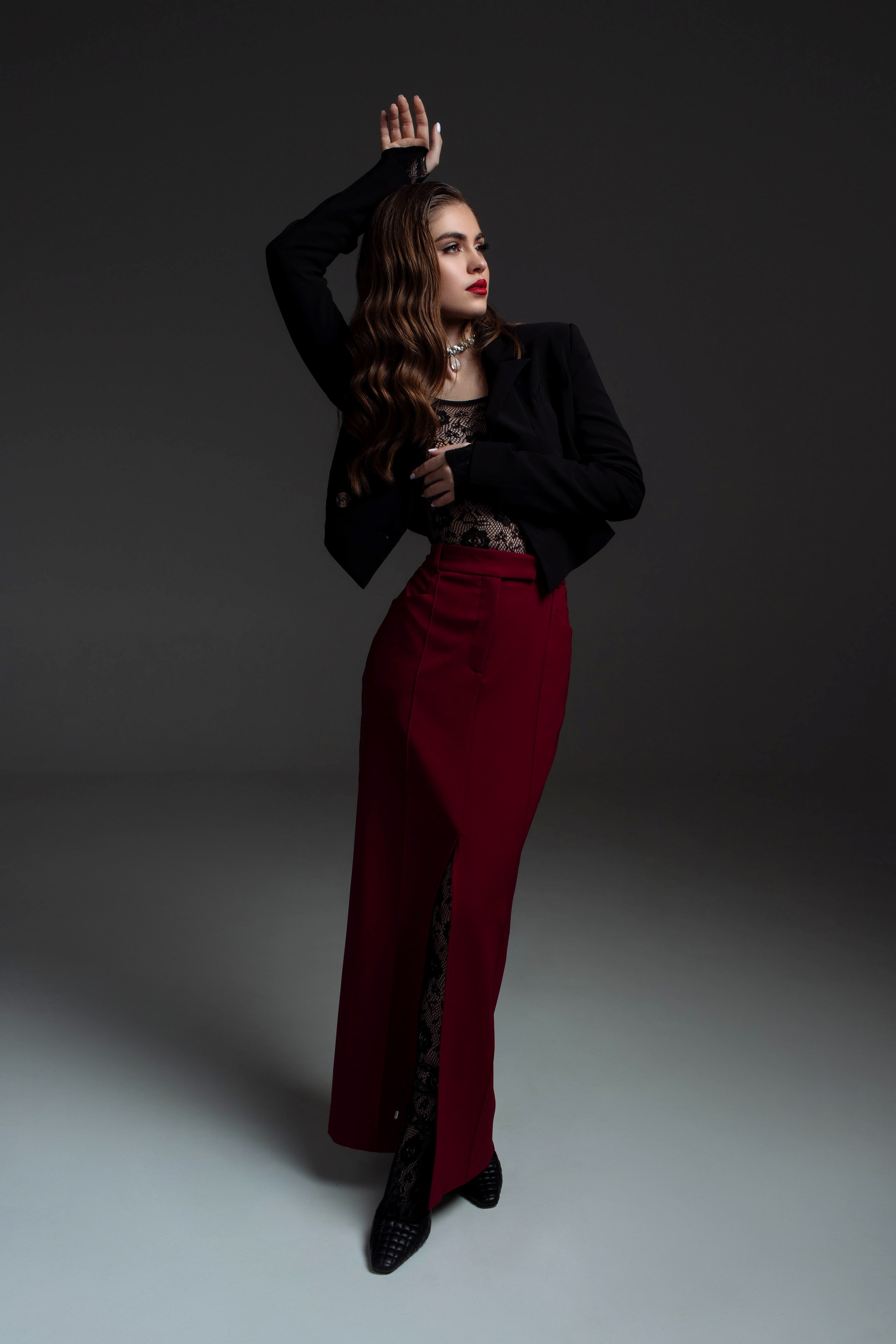 Съемка в студии. Девушка в черном пиджаке и красной юбке
