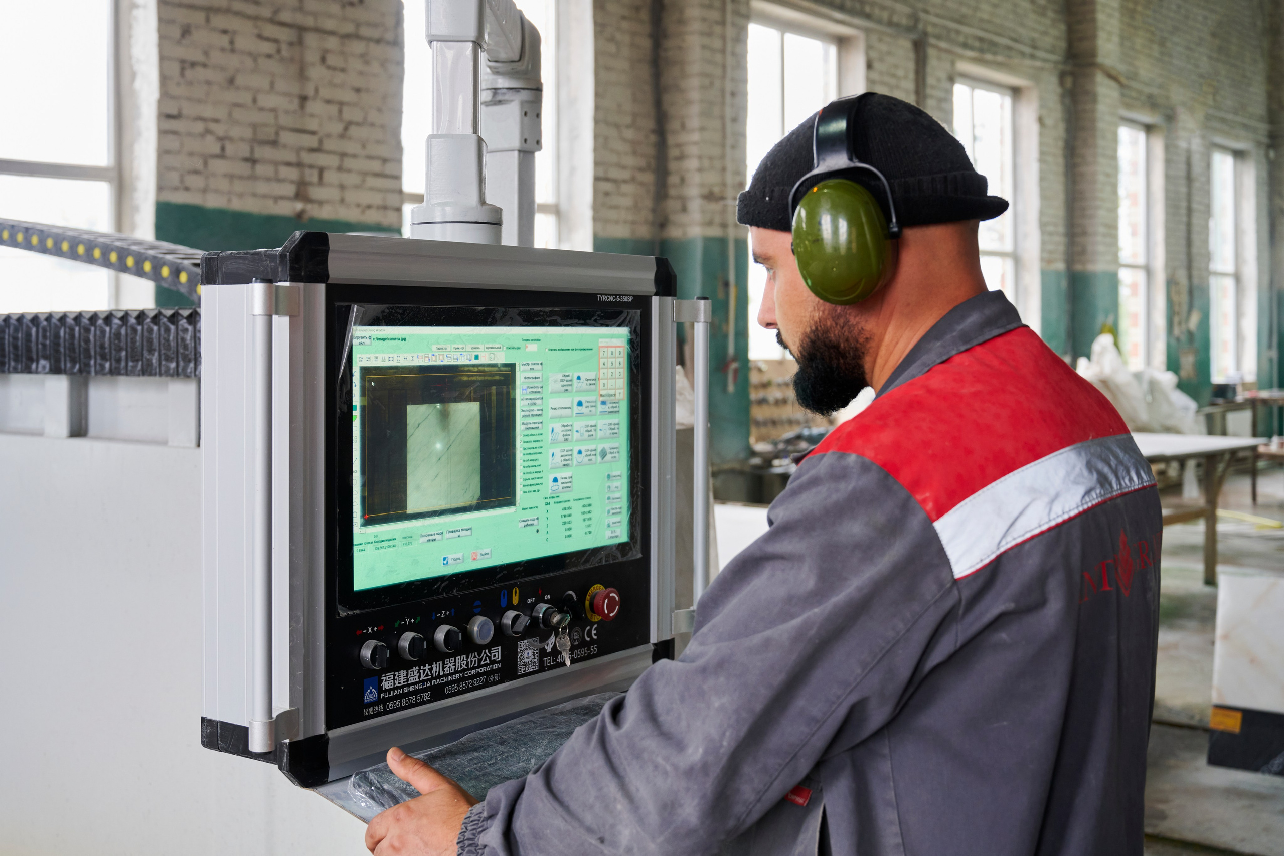 Оператор у станка с монитором, контроль резки камня