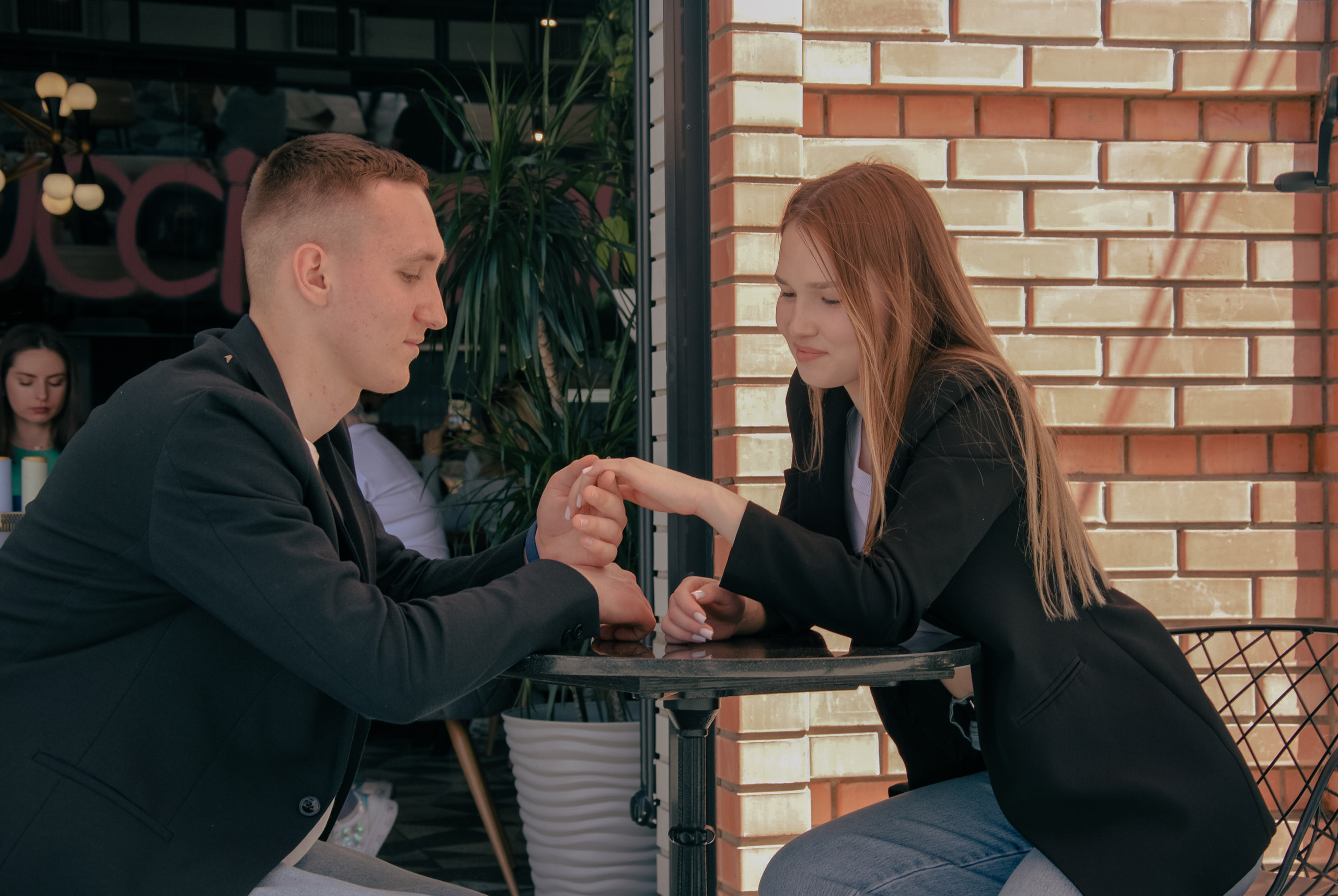 Влюбленные в кафе за столиком мило беседуют не обращая внимание ни на кого.